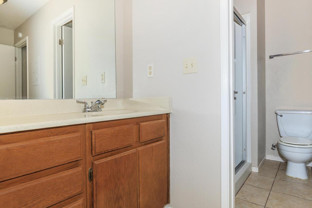 a white sink sitting under a mirror