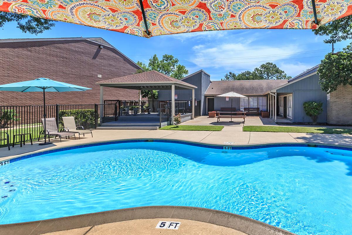 a blue umbrella sitting on the side of a swimming pool