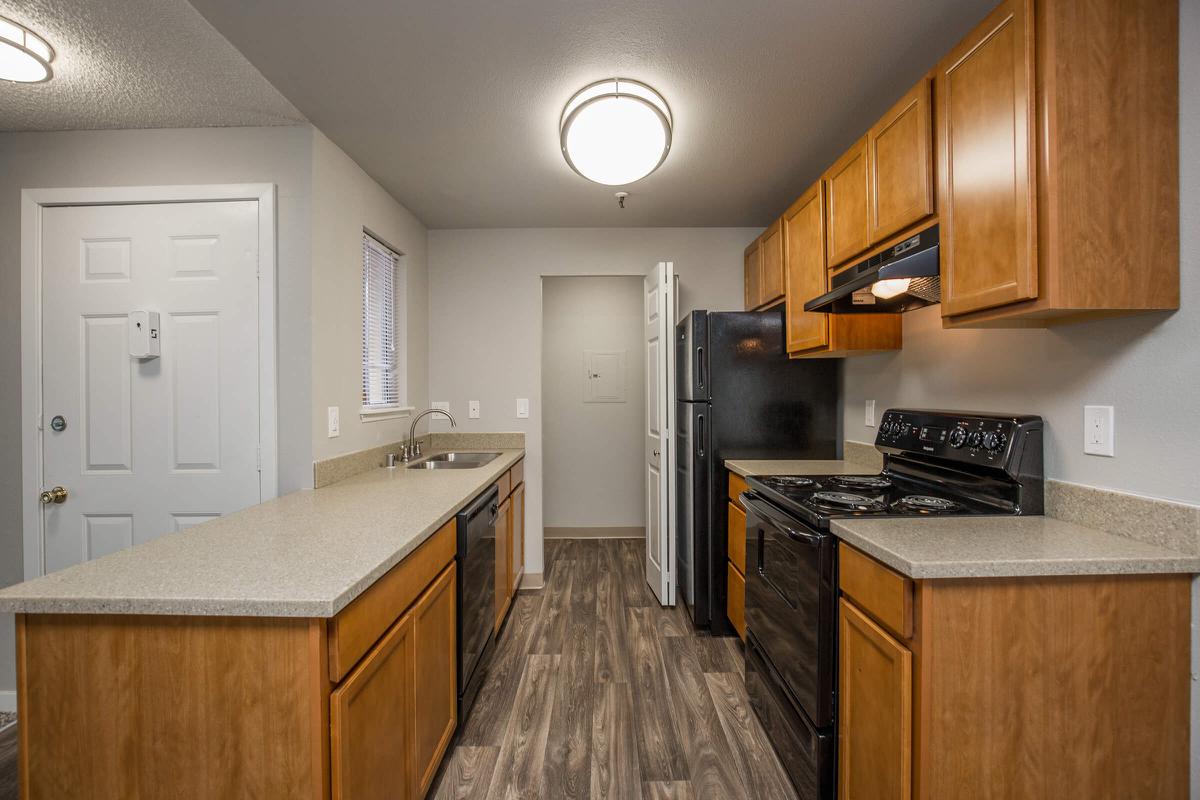 a large kitchen with stainless steel appliances and wooden cabinets