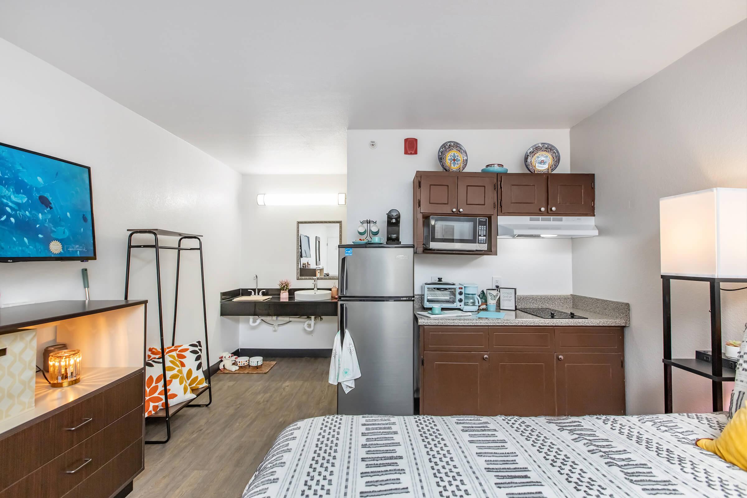 a bedroom with a bed and desk in a room