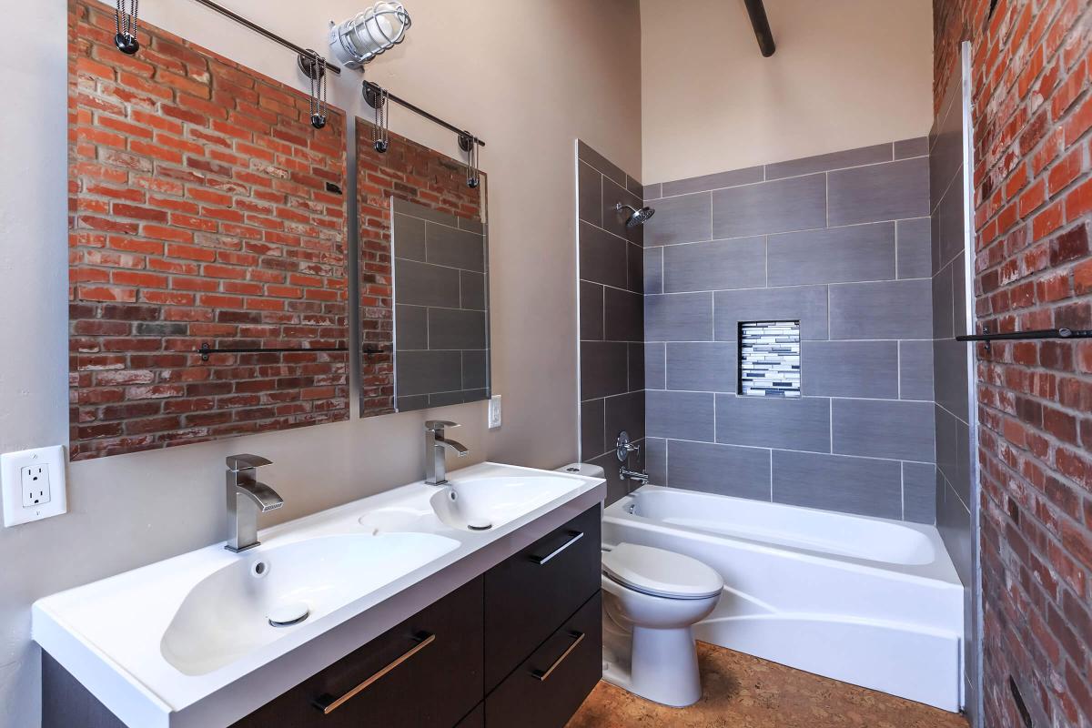 a white sink sitting next to a brick wall