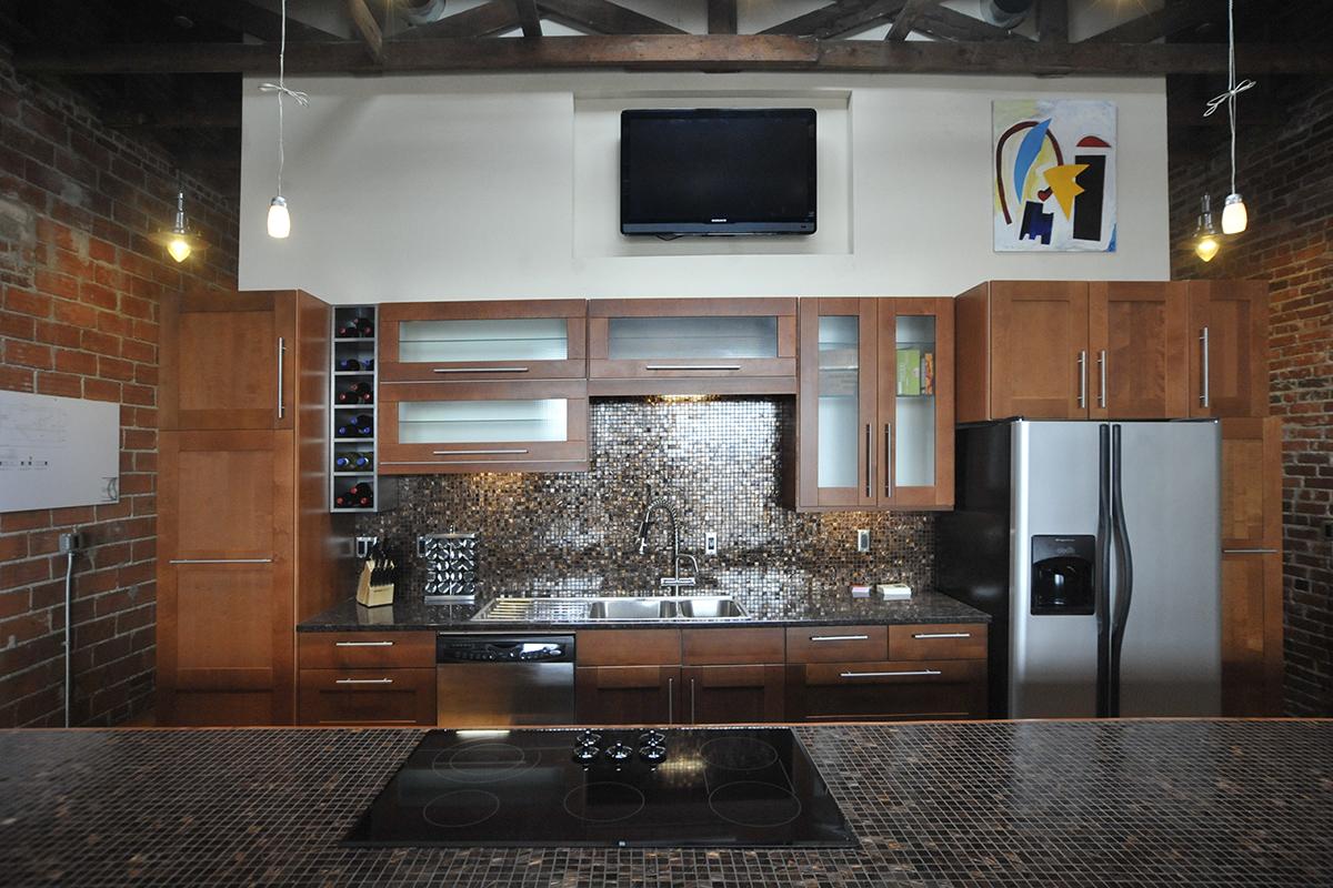 a modern kitchen with stainless steel appliances and wooden cabinets