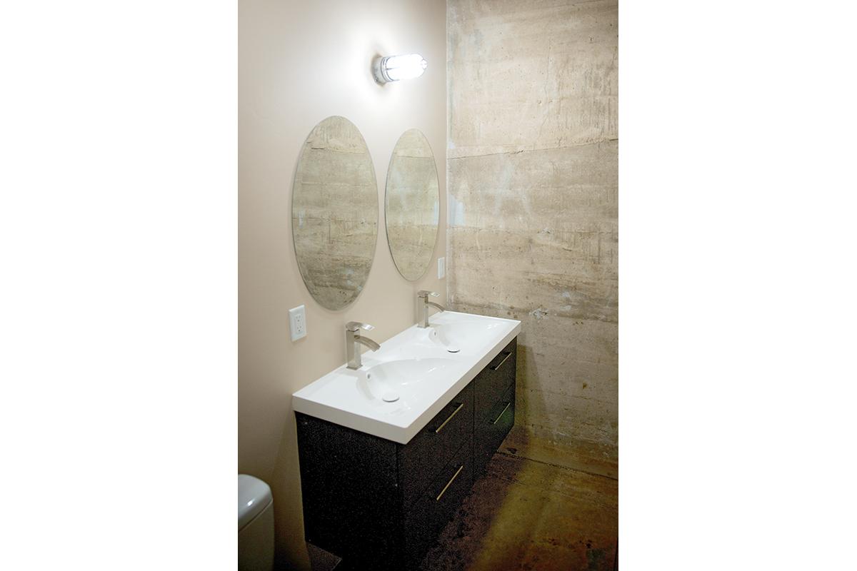 a white sink sitting under a mirror