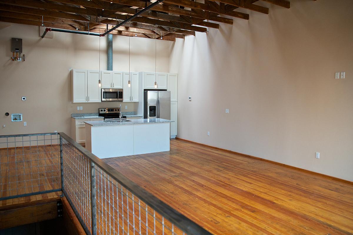 a kitchen with wooden cabinets and a wood floor