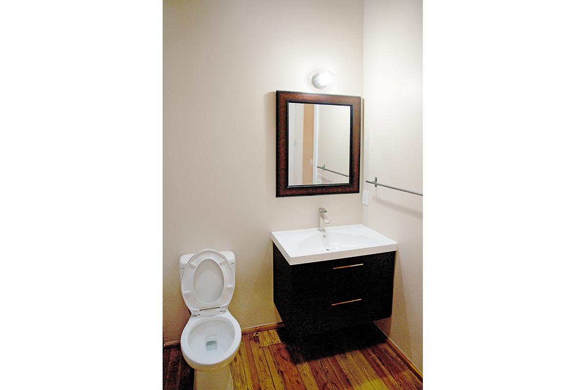 a white sink sitting under a mirror