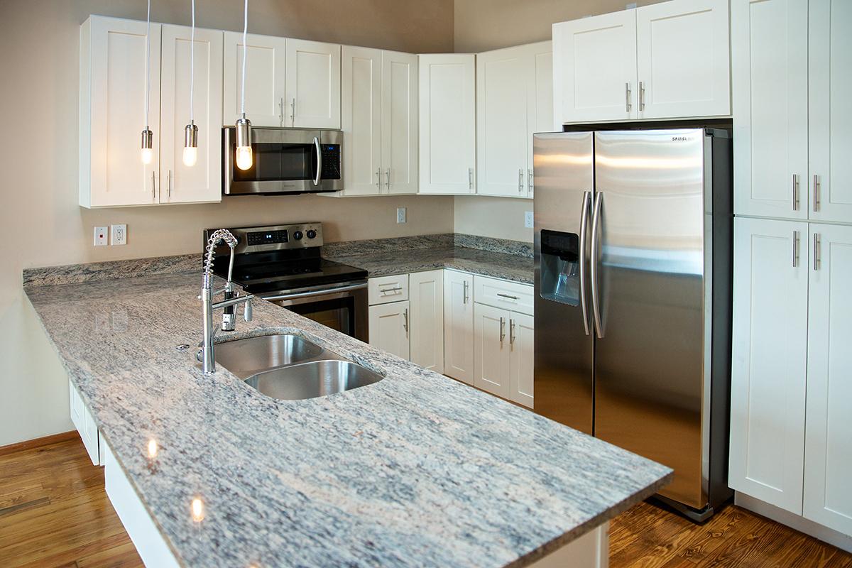 a modern kitchen with stainless steel appliances and wooden cabinets