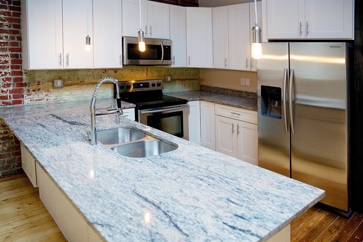 a modern kitchen with stainless steel appliances and wooden cabinets