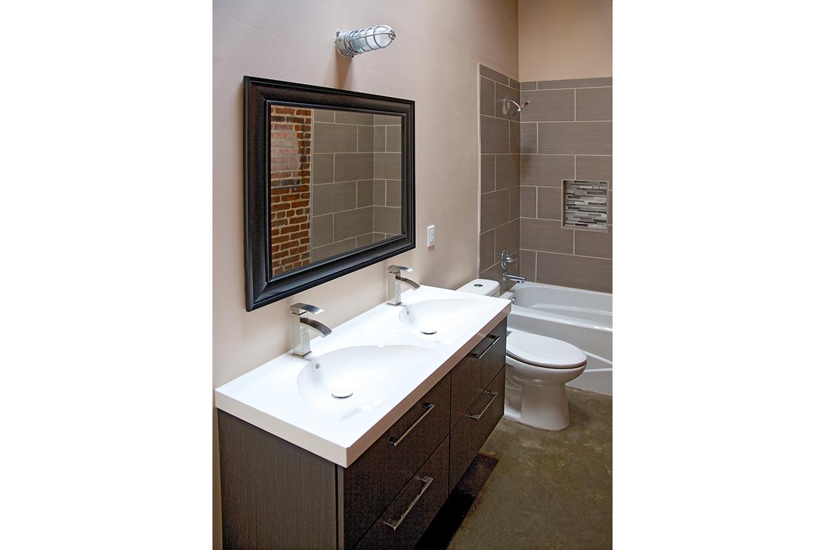 a white sink sitting under a mirror