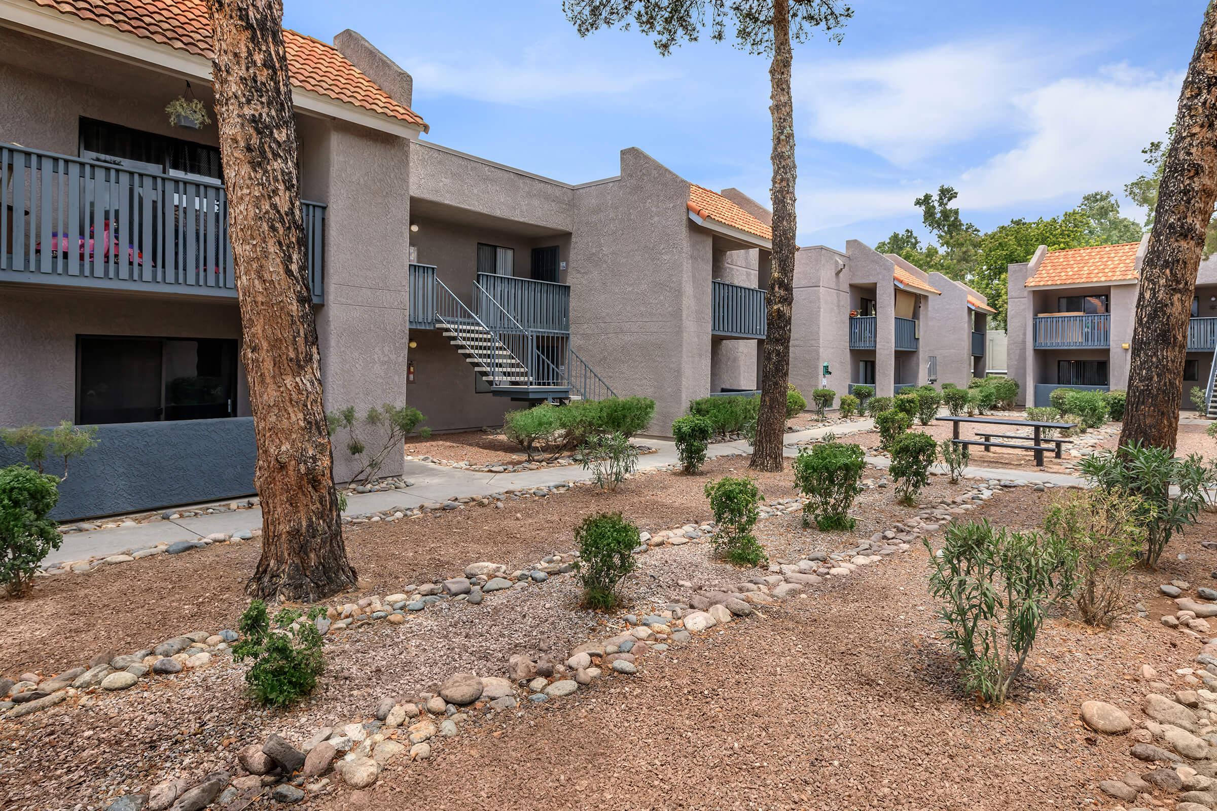 a dirt path in front of a brick building