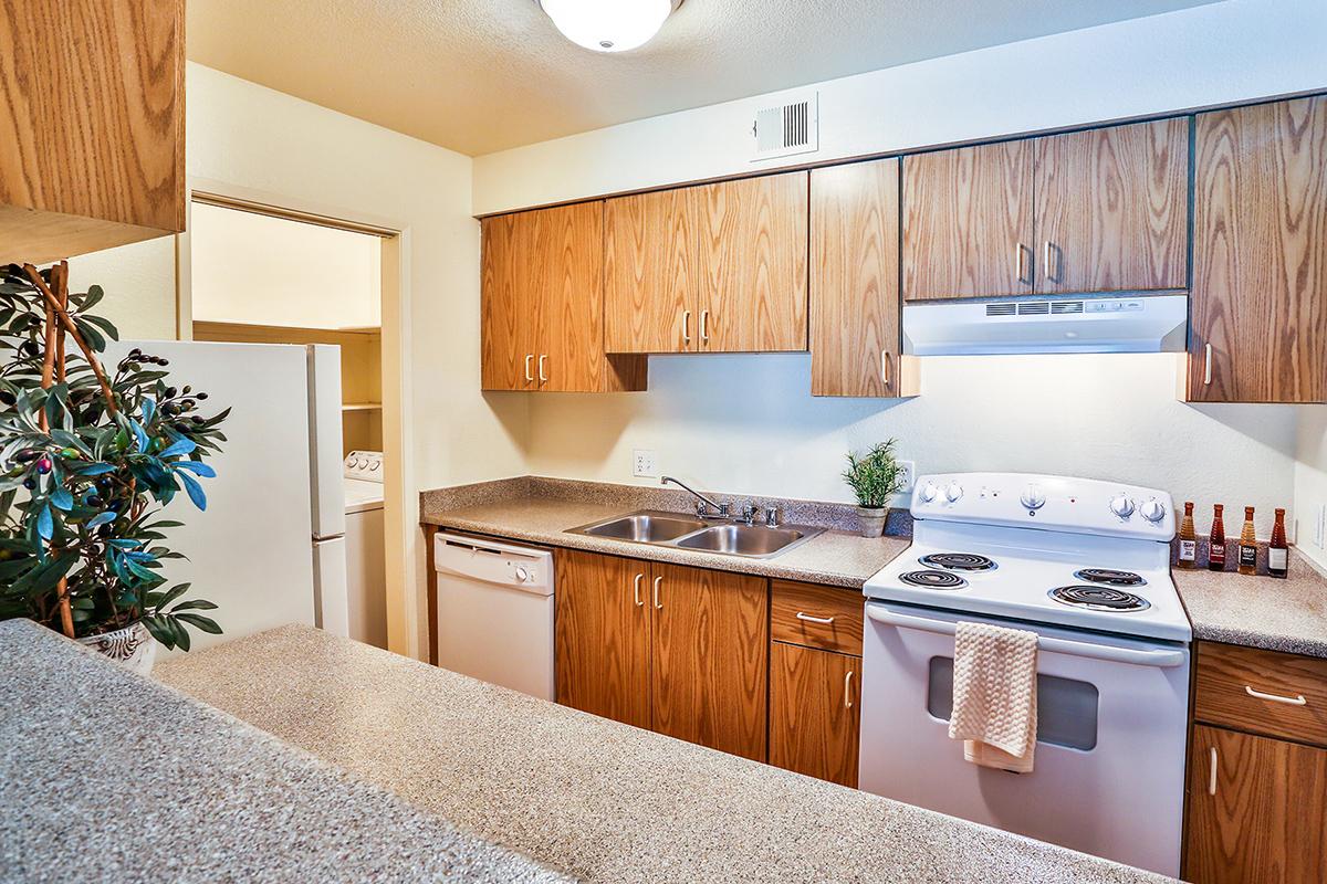 a kitchen with wooden cabinets and a bed in a room