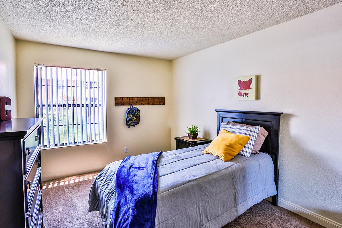 a bedroom with a bed and desk in a room
