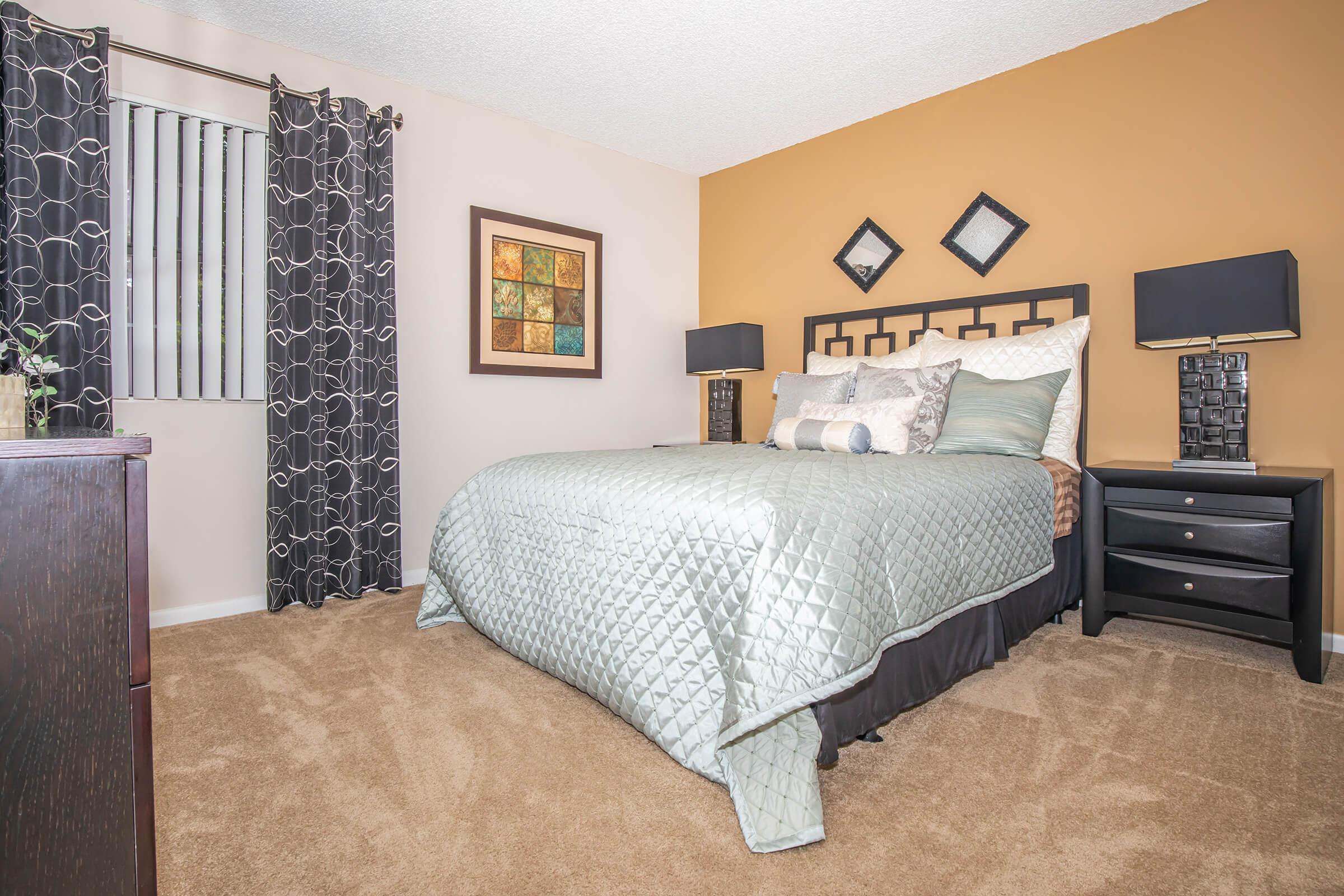 a bedroom with a bed and desk in a room