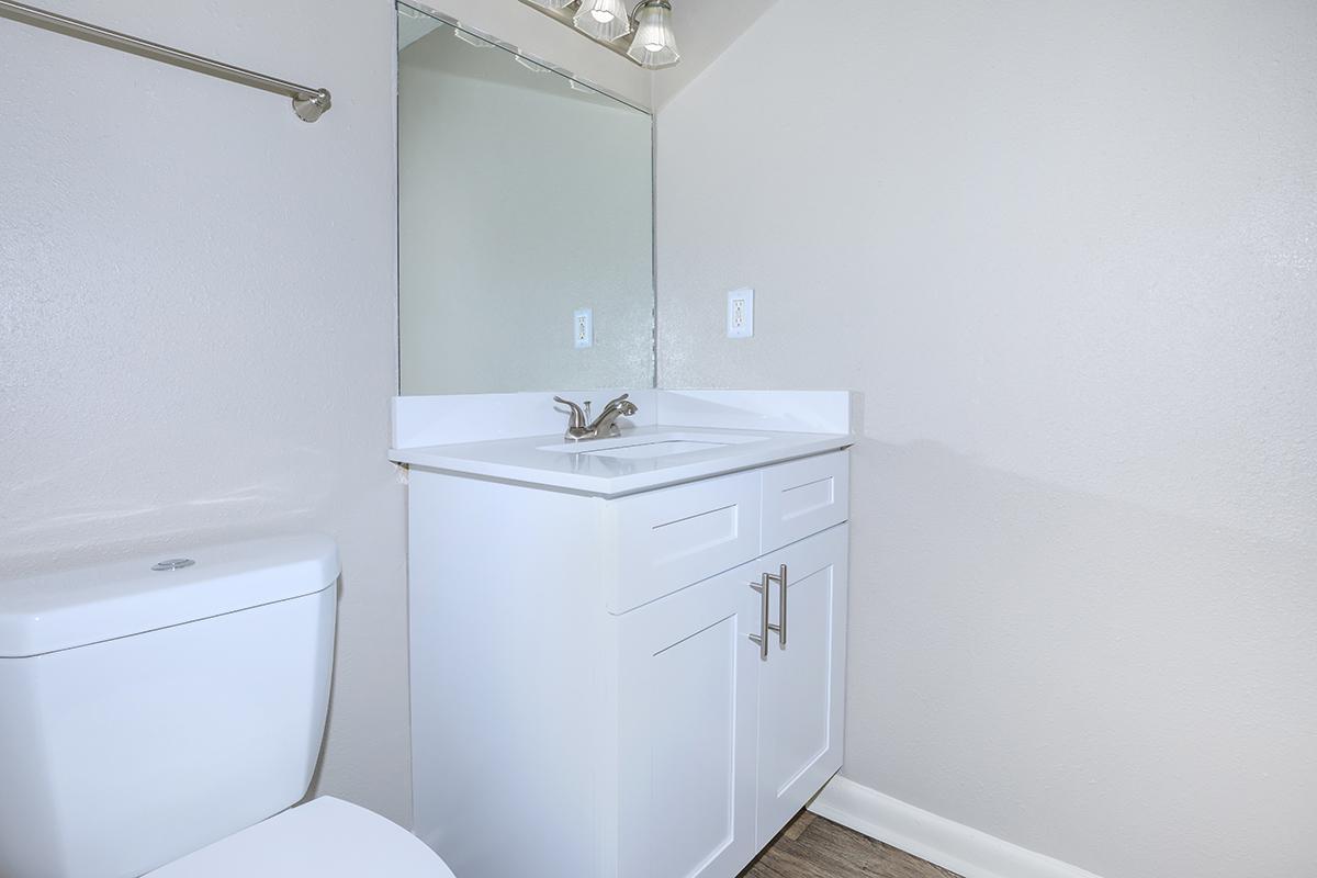 a white sink sitting under a mirror