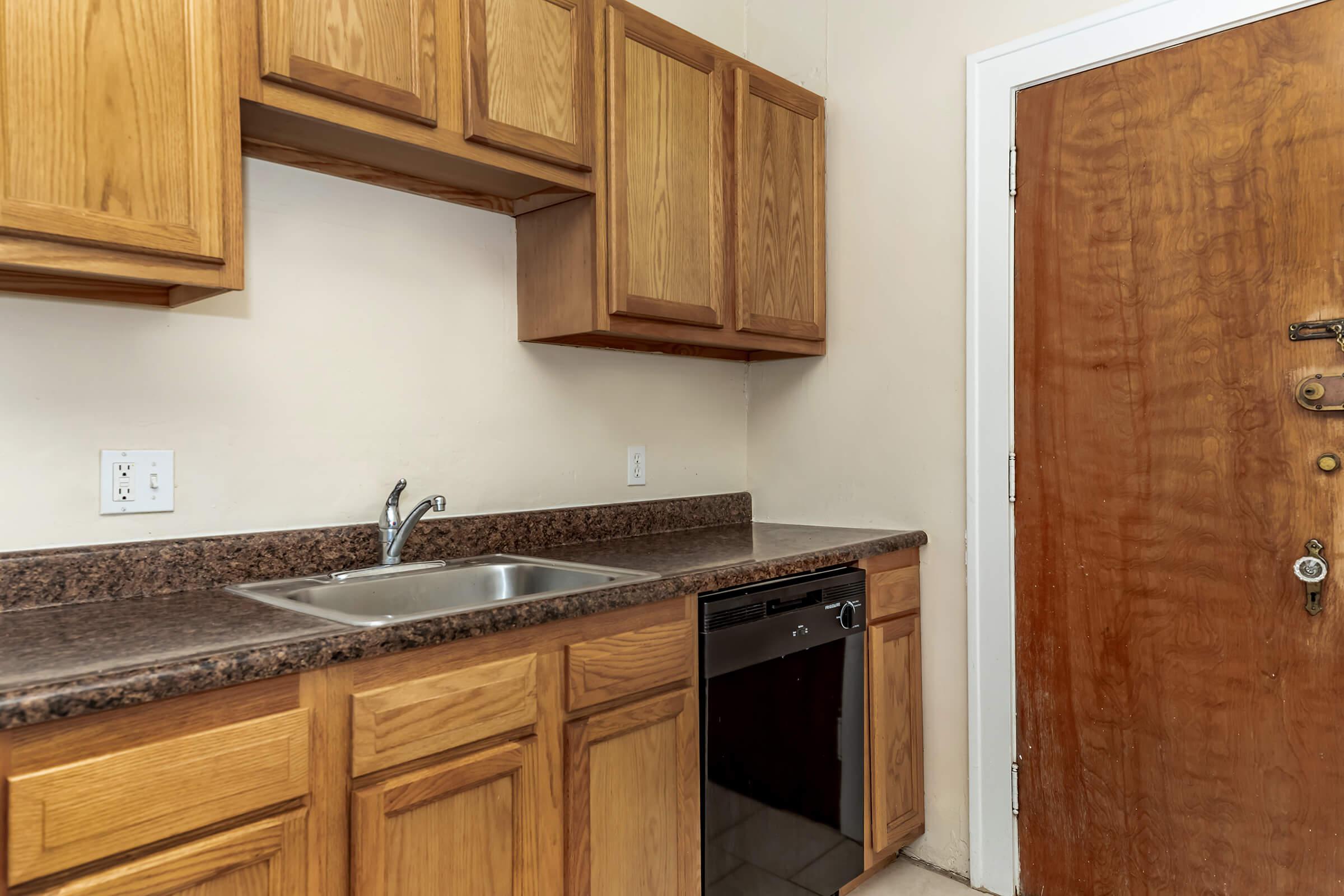 a kitchen with wooden cabinets and a sink