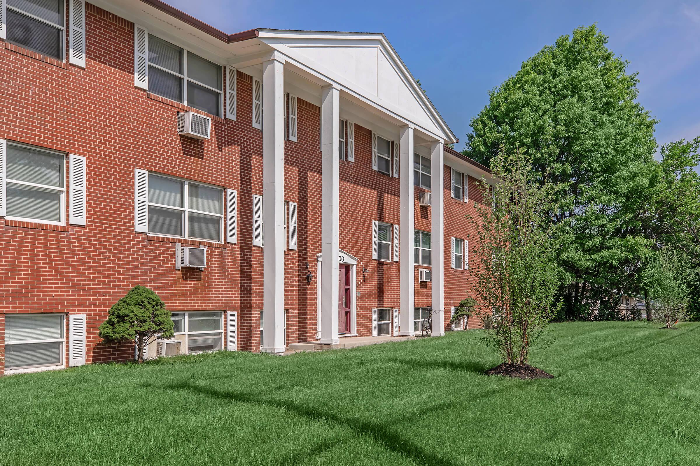 a large lawn in front of a brick building