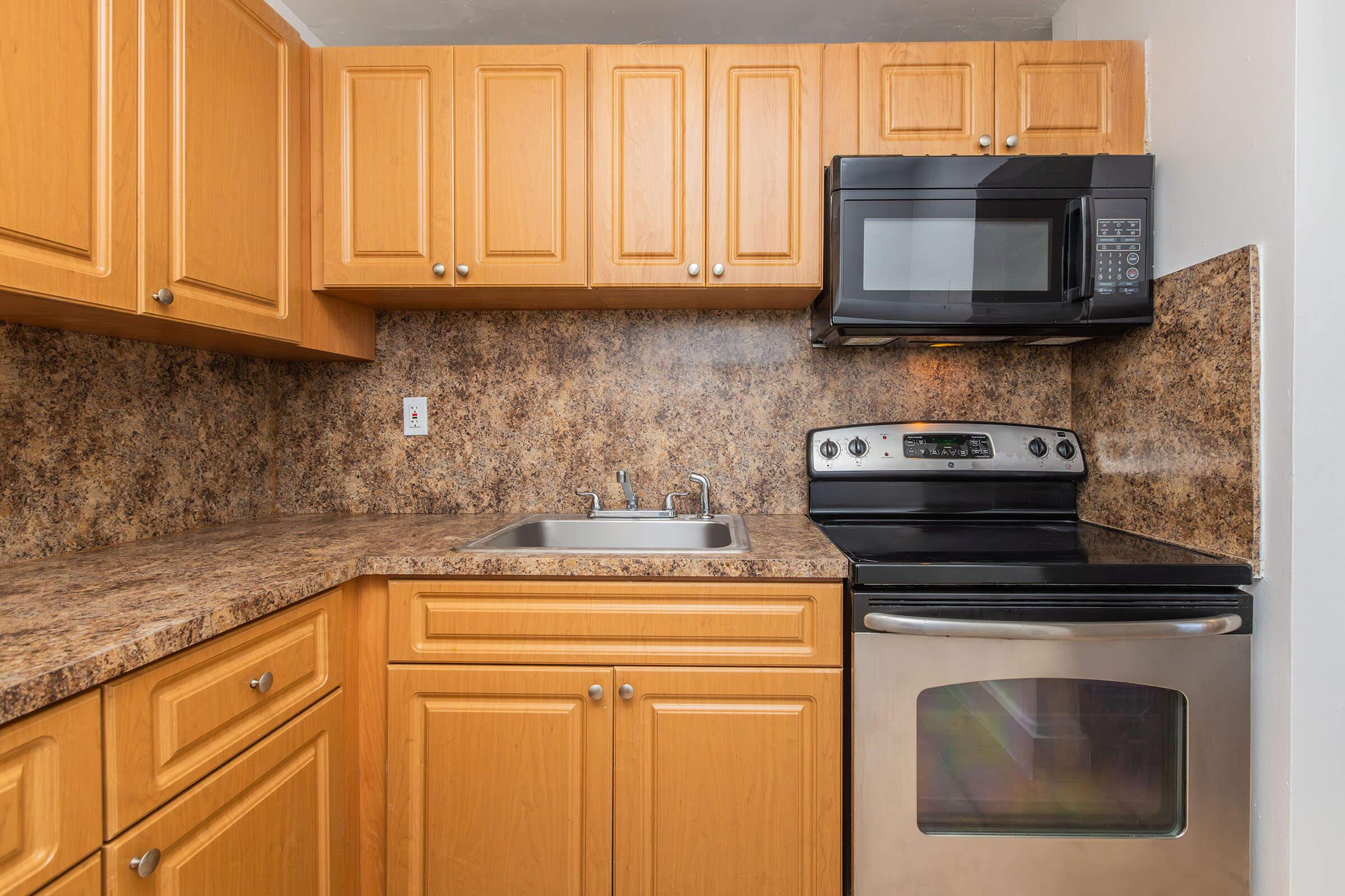 a kitchen with wooden cabinets and a microwave