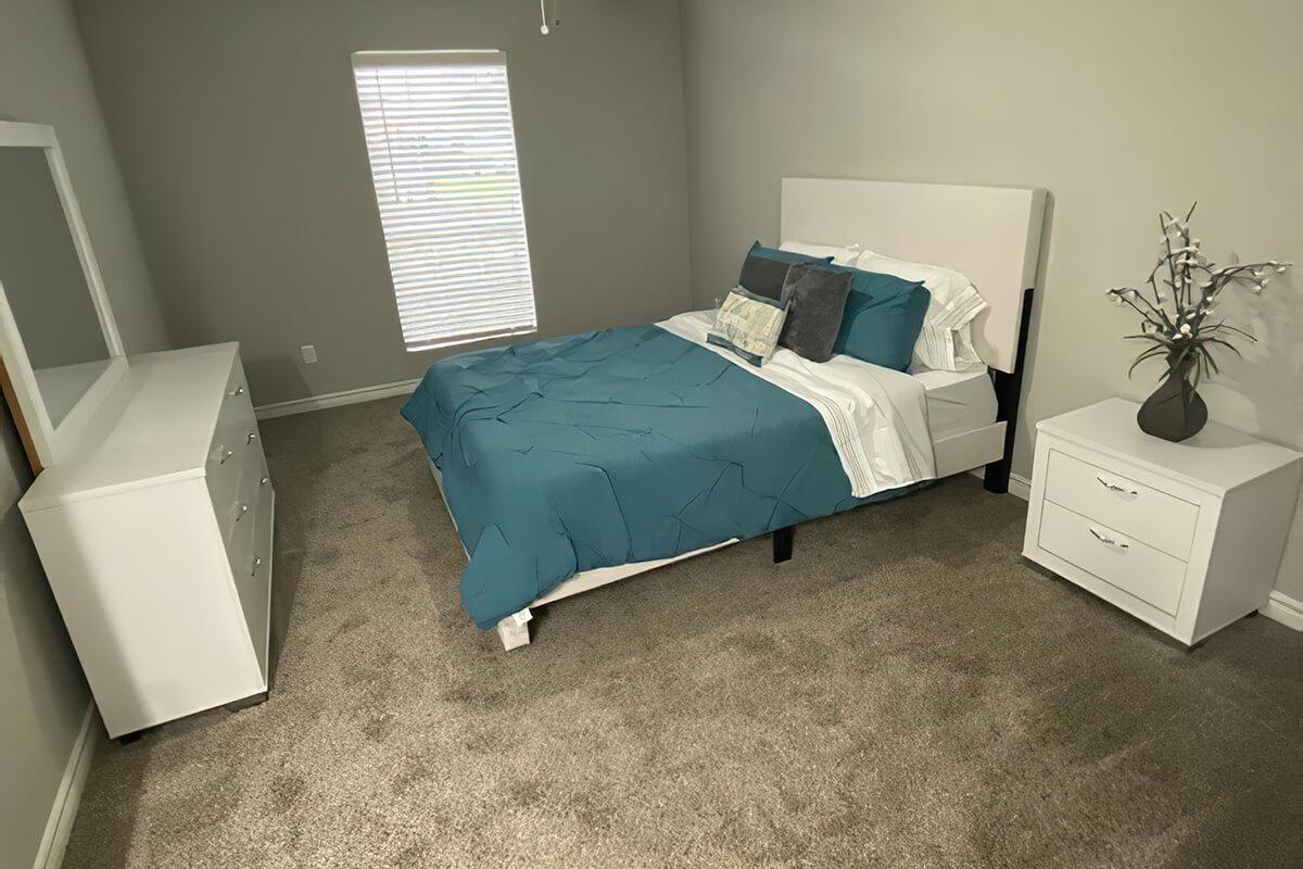 a bedroom with a bed and desk in a room