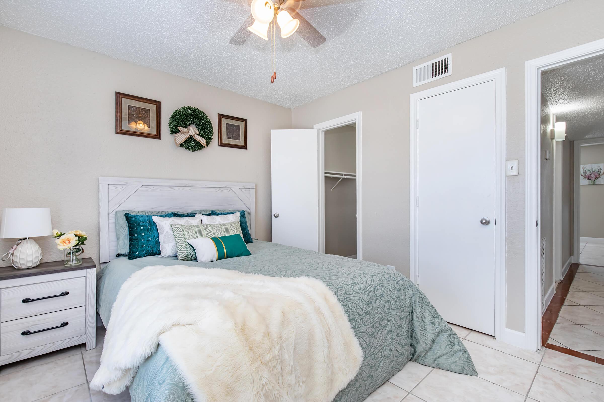 a bedroom with a bed and a mirror in a room