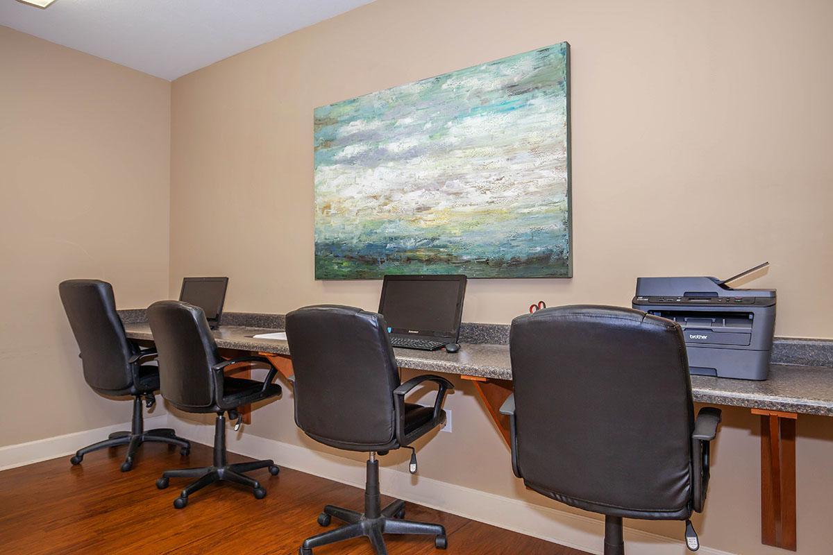 a desk with a computer and a chair in a room