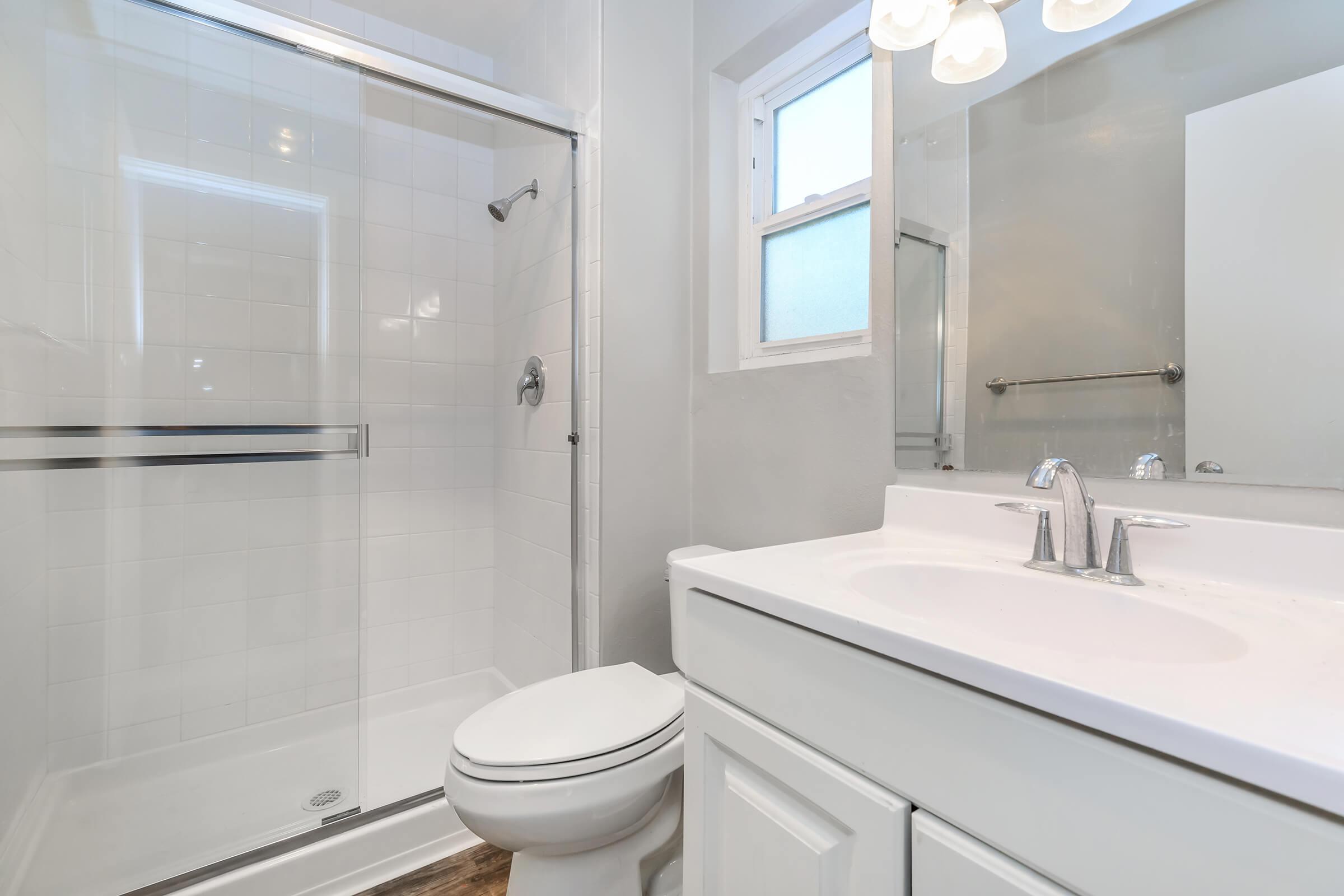 a white sink sitting next to a shower