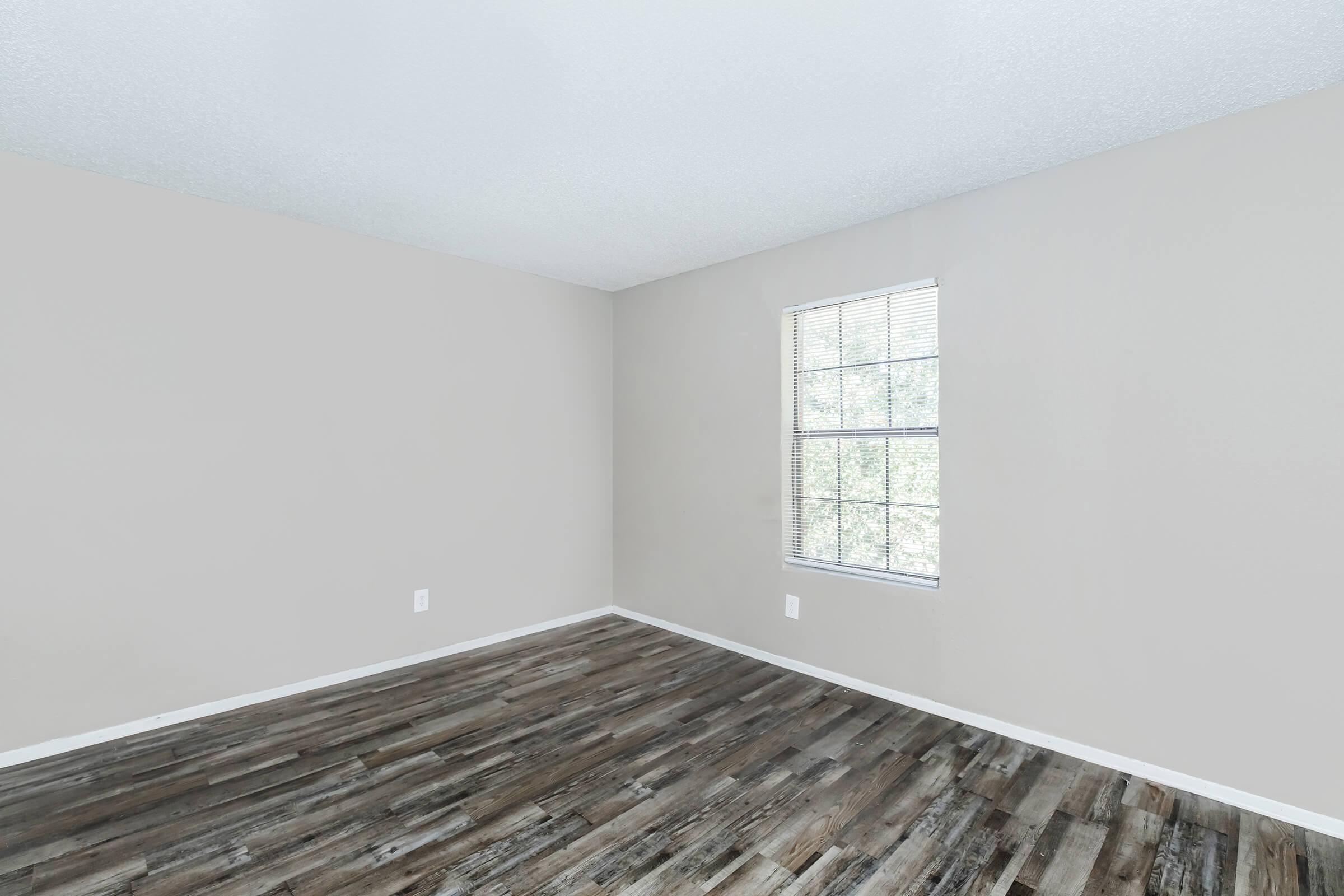 a bedroom with a wooden floor