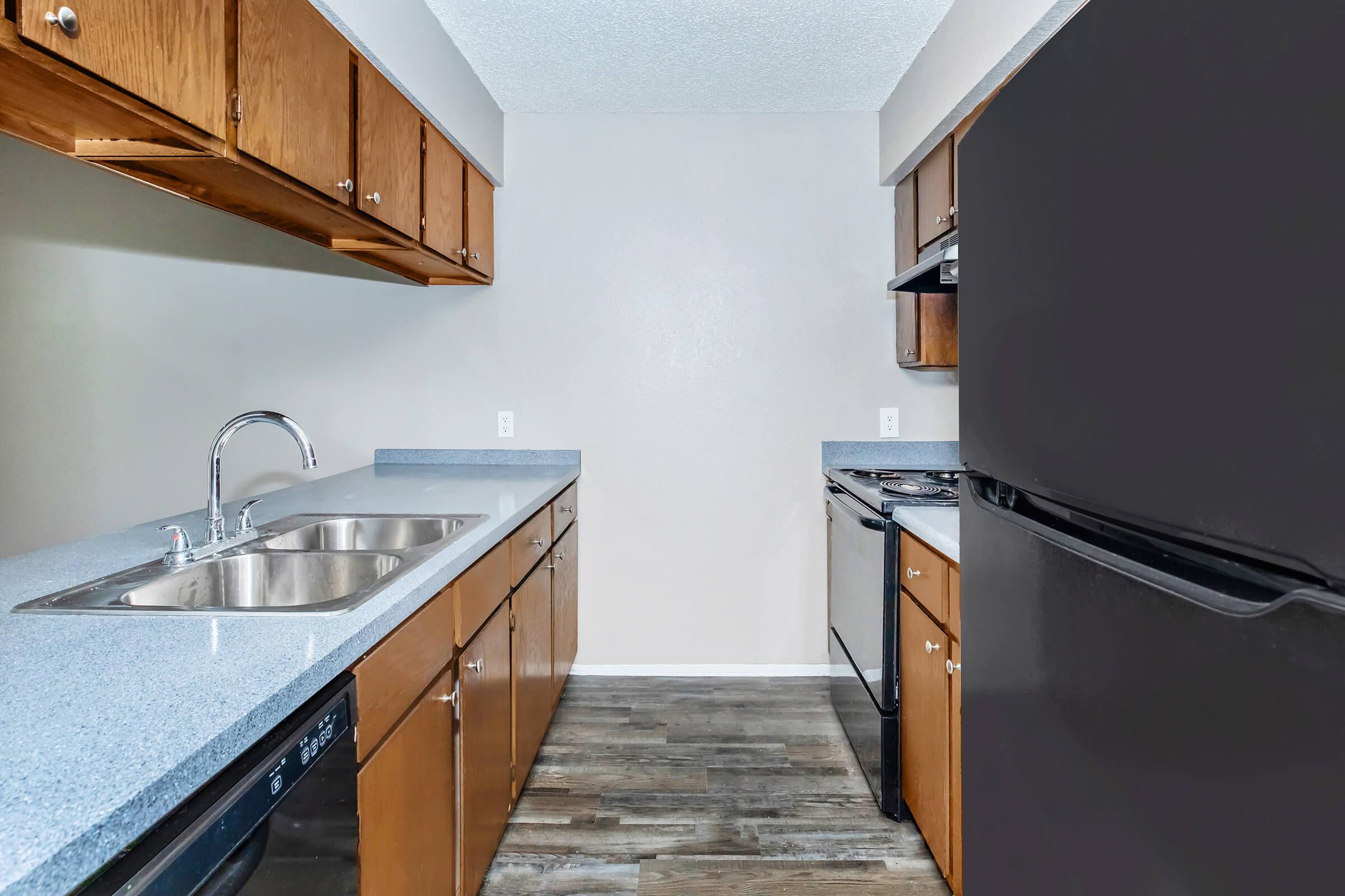 a large kitchen with stainless steel appliances and wooden cabinets