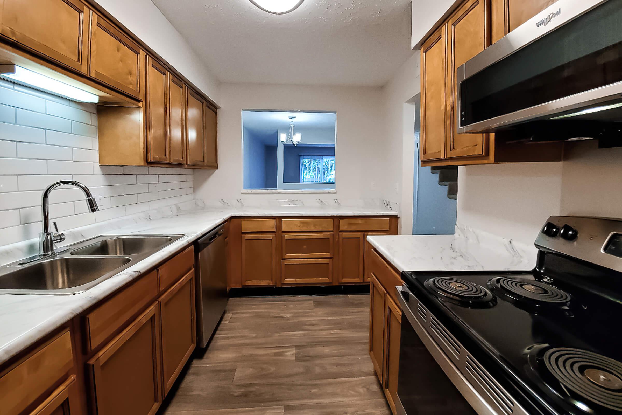 a large kitchen with stainless steel appliances and wooden cabinets