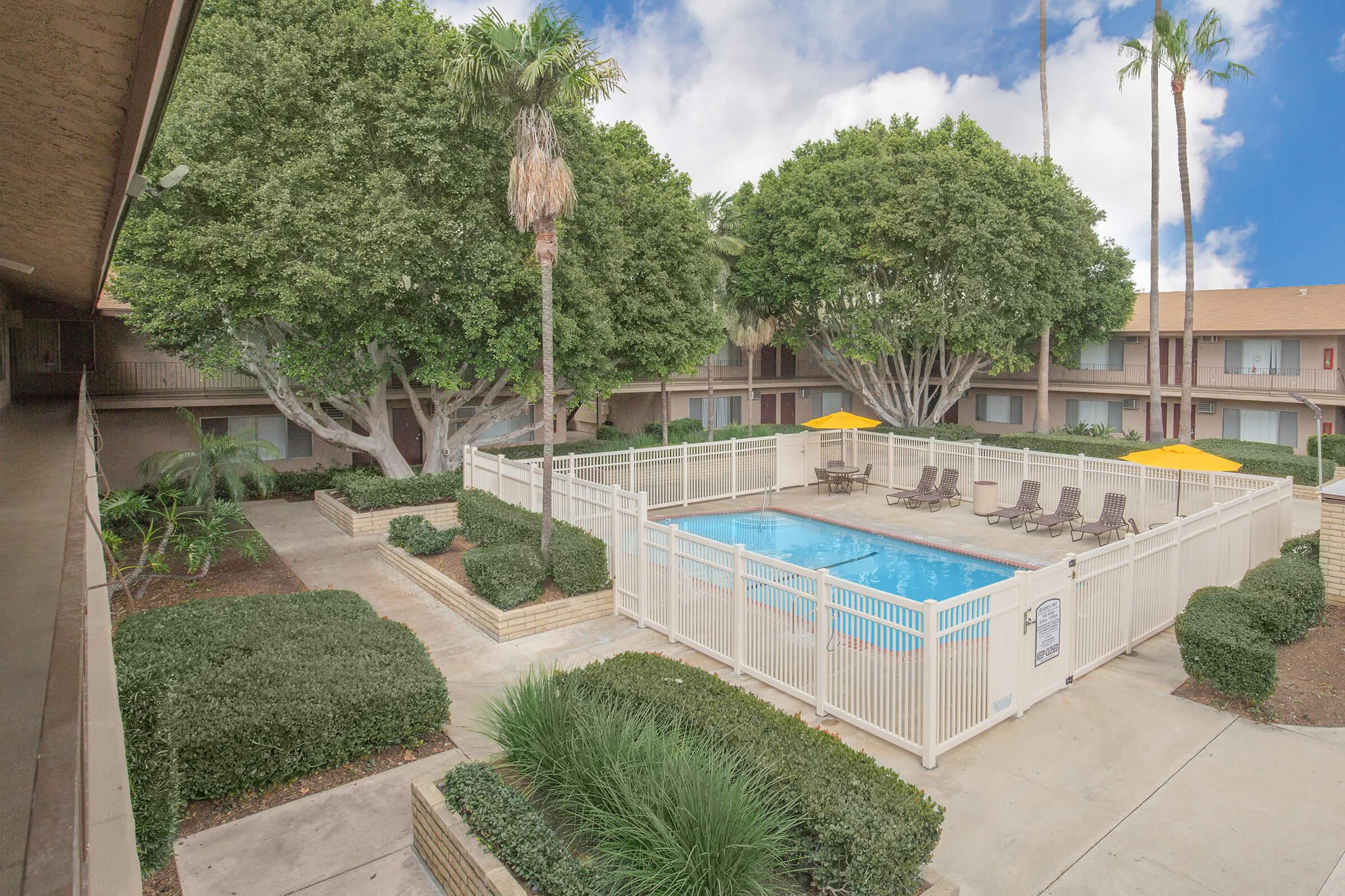 Castilian and Cordova Apartment Homes community pool surrounded by green landscaping