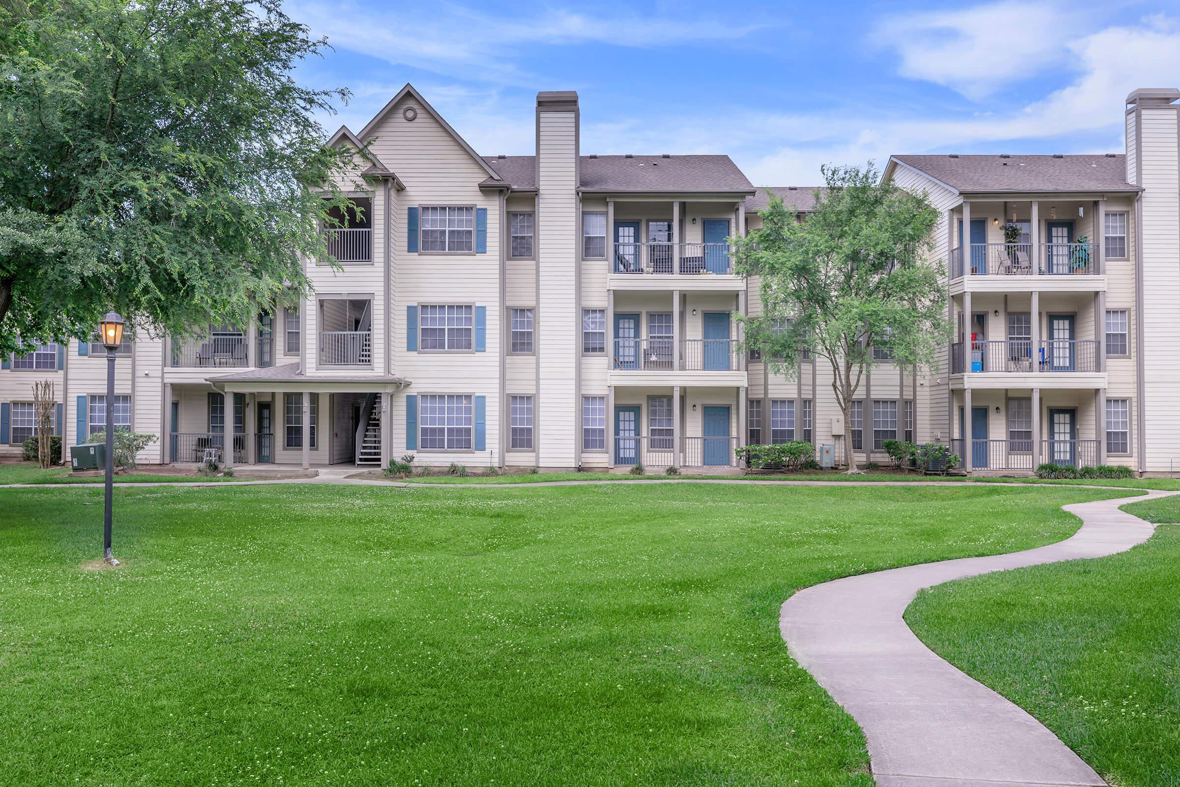 a large lawn in front of a brick building