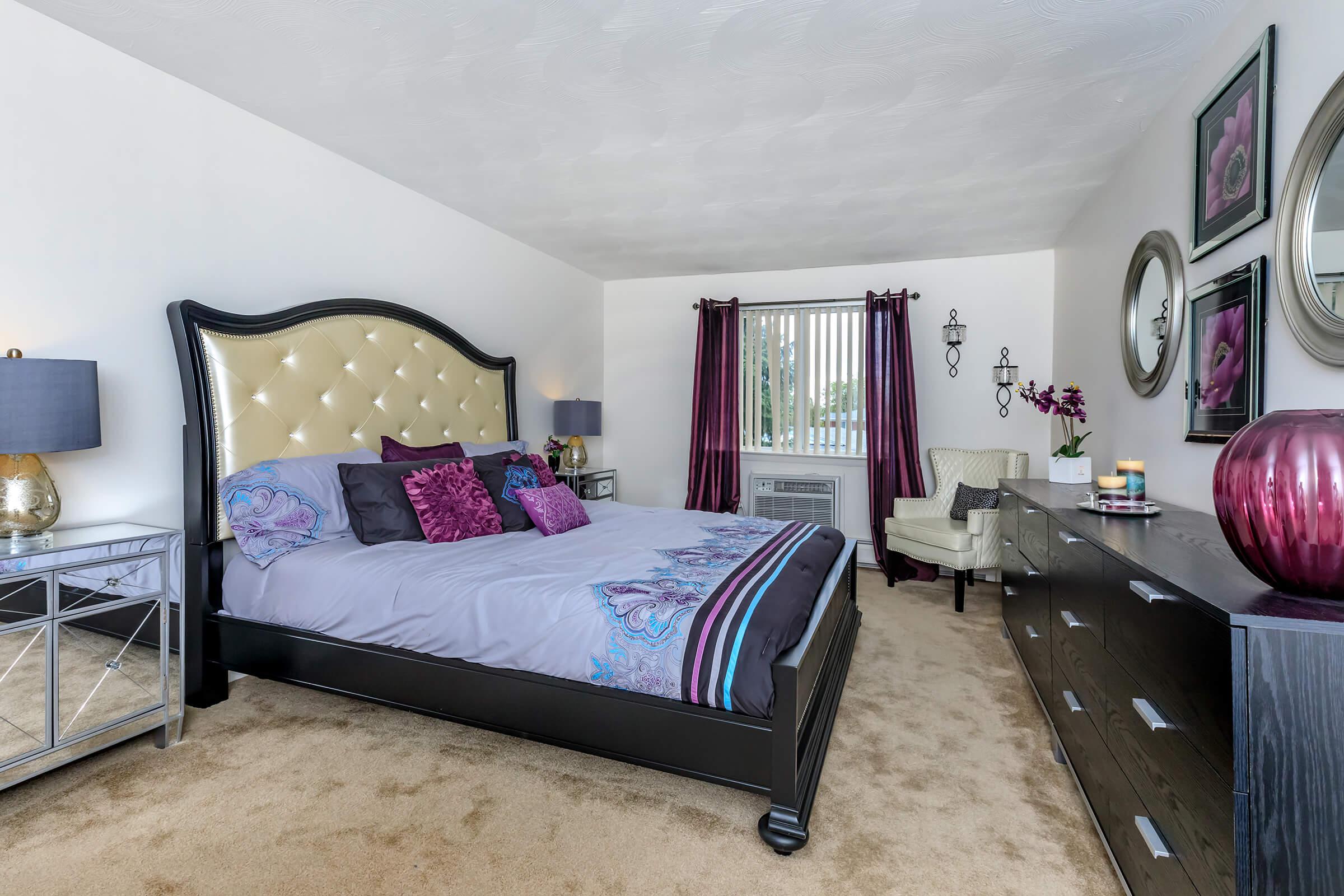 a bedroom with a bed and desk in a room