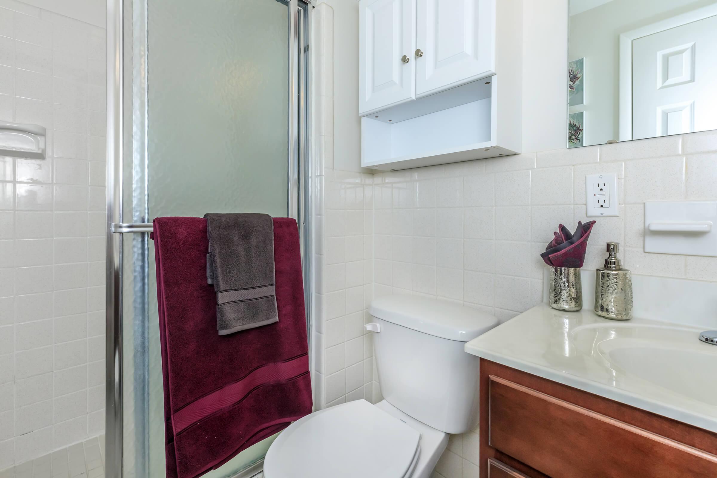 a white sink sitting under a mirror
