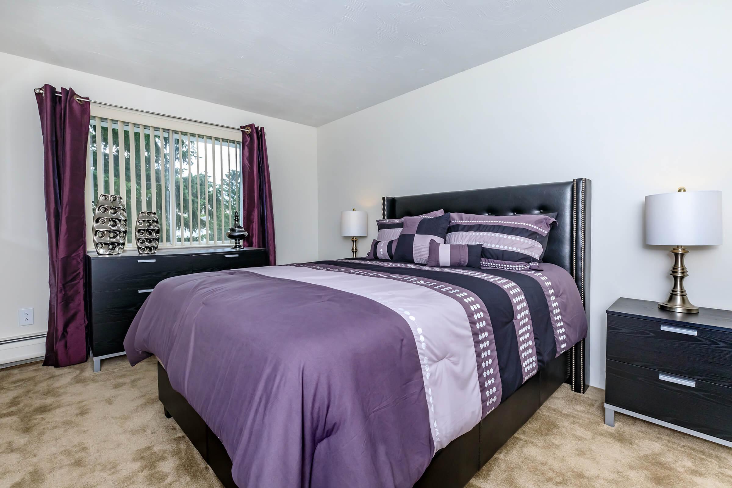 a bedroom with a bed and desk in a hotel room