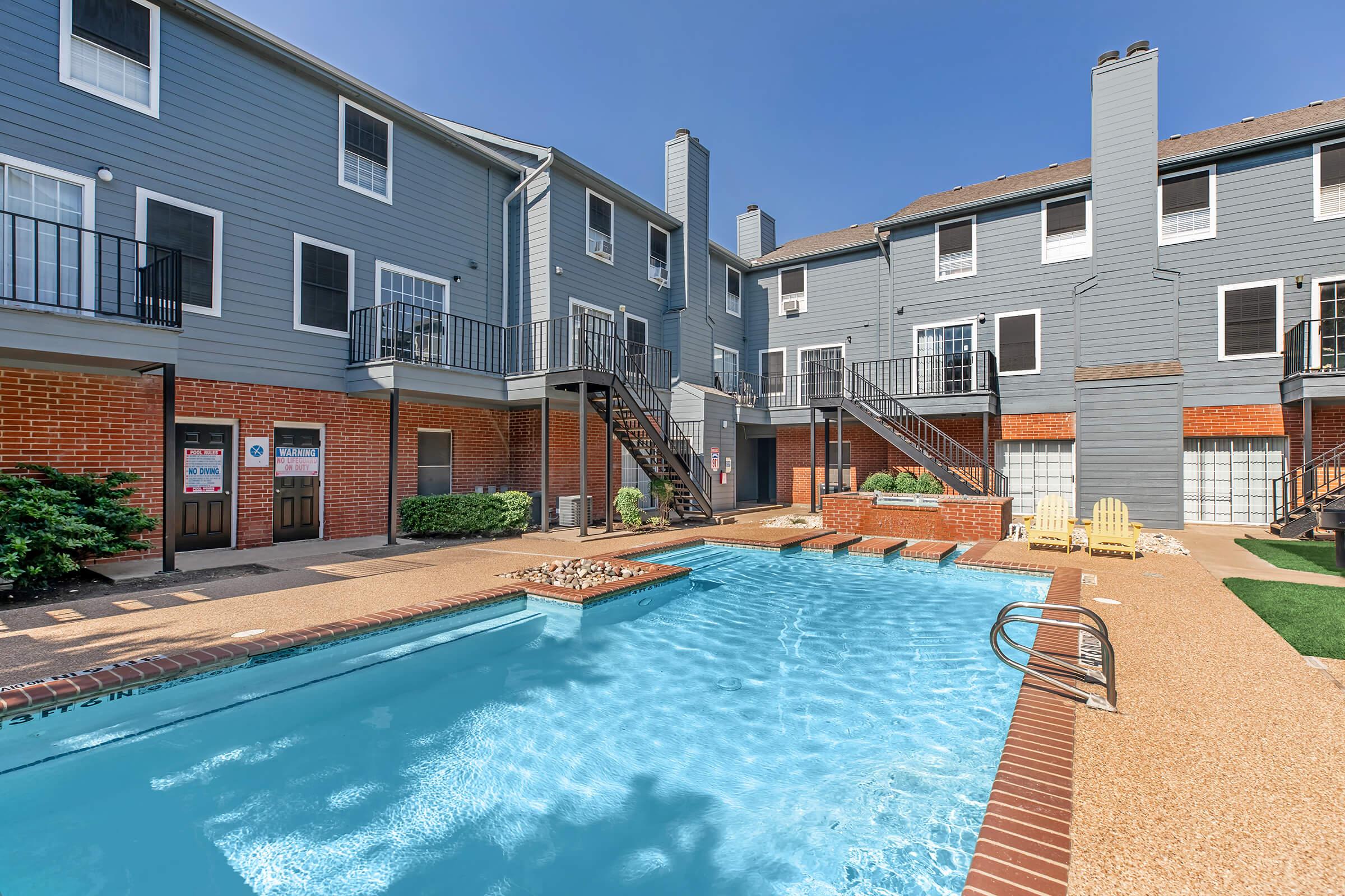 a large brick building with a pool of water