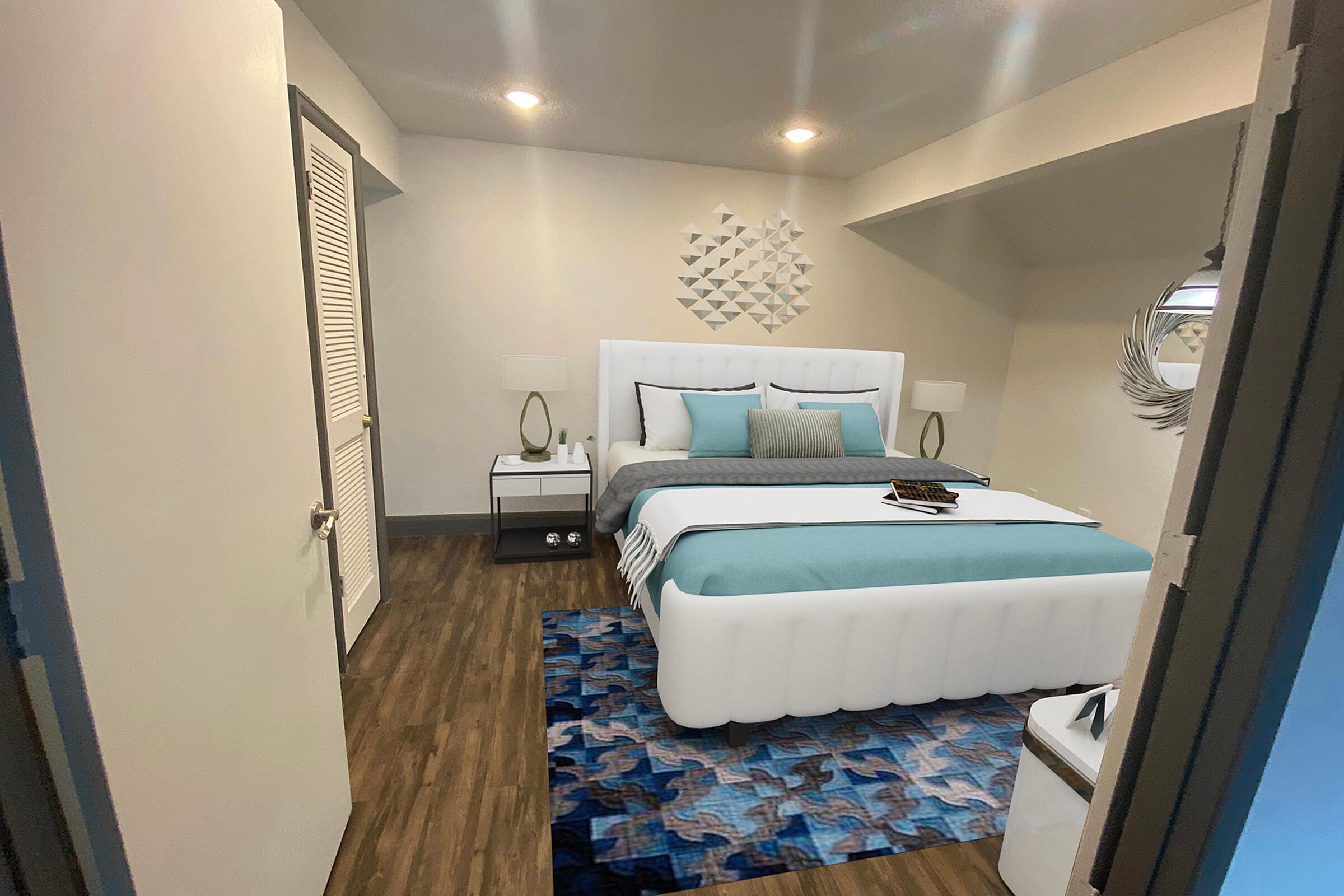 A modern bedroom featuring a white upholstered bed with teal and gray bedding. There are two bedside tables with lamps, a decorative wall piece, and a patterned area rug on dark wood flooring. The room is well-lit with ceiling lights and has a clean, minimalist design.