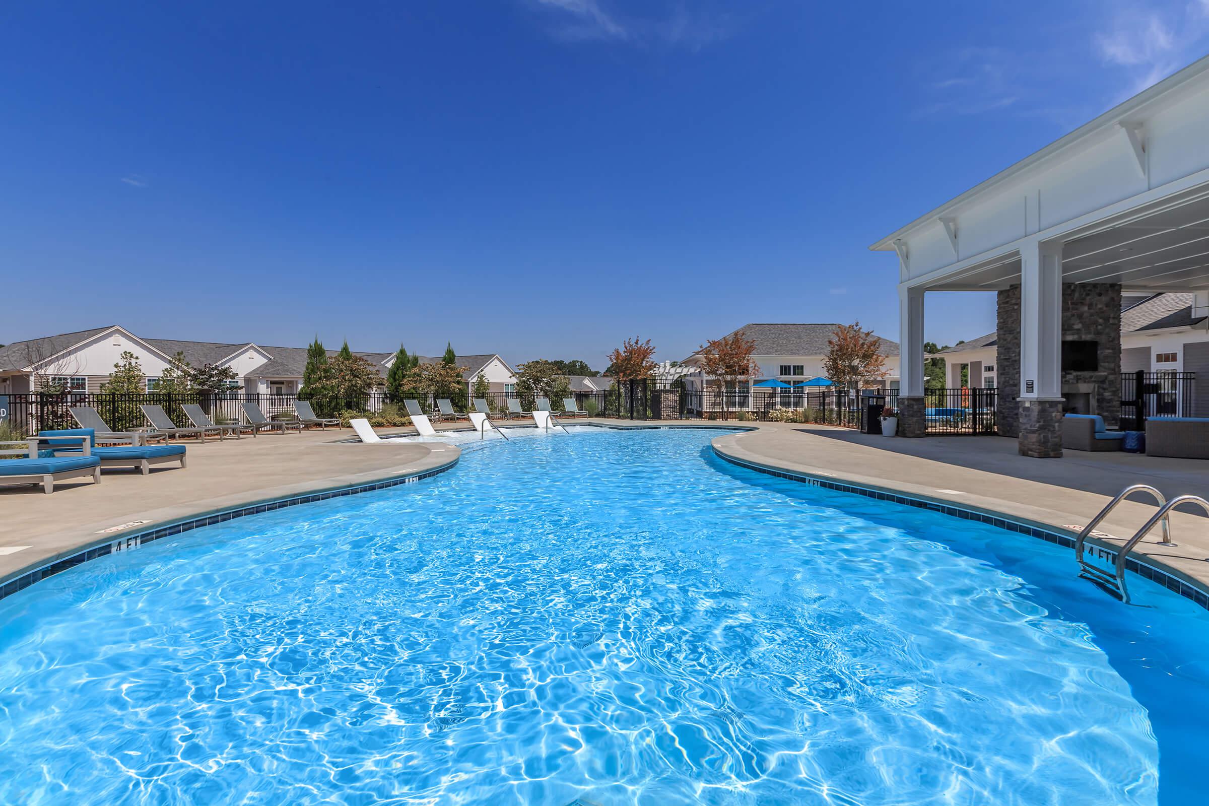 Dive Into A Shimmering Swimming Pool At Riverstone Apartments At Long Shoals In Arden, North Carolina