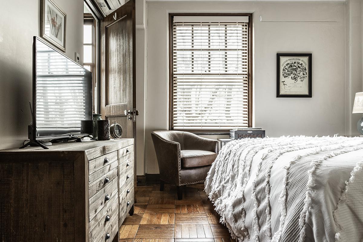a bedroom with a bed and desk in a room