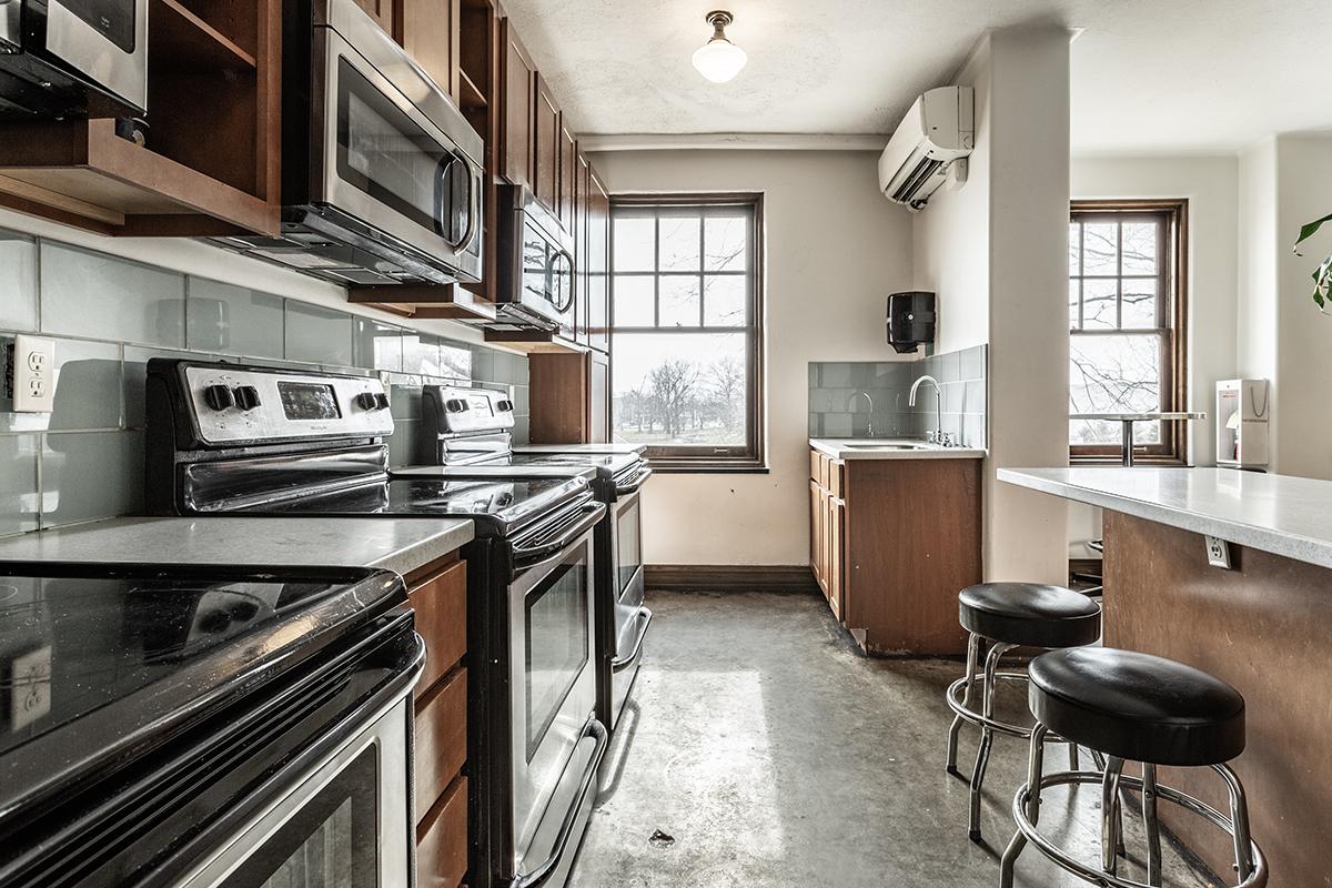 a kitchen with a stove top oven sitting next to a window