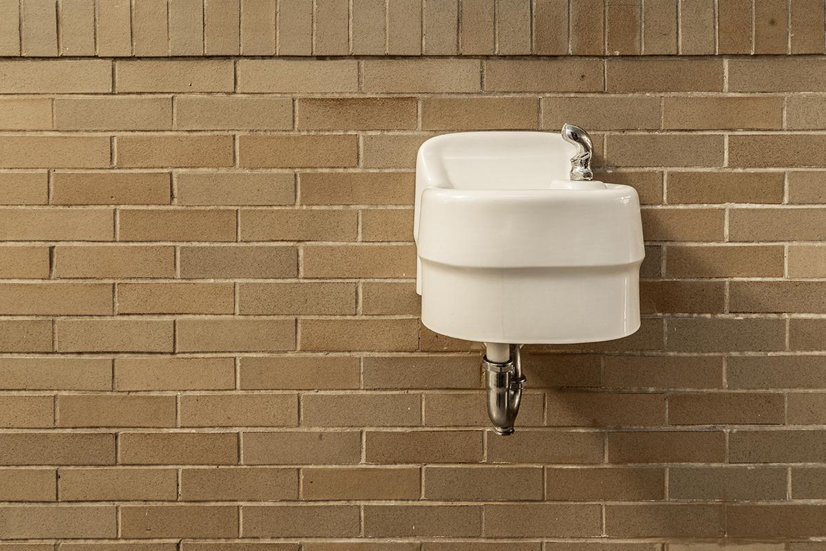 a person standing next to a brick wall