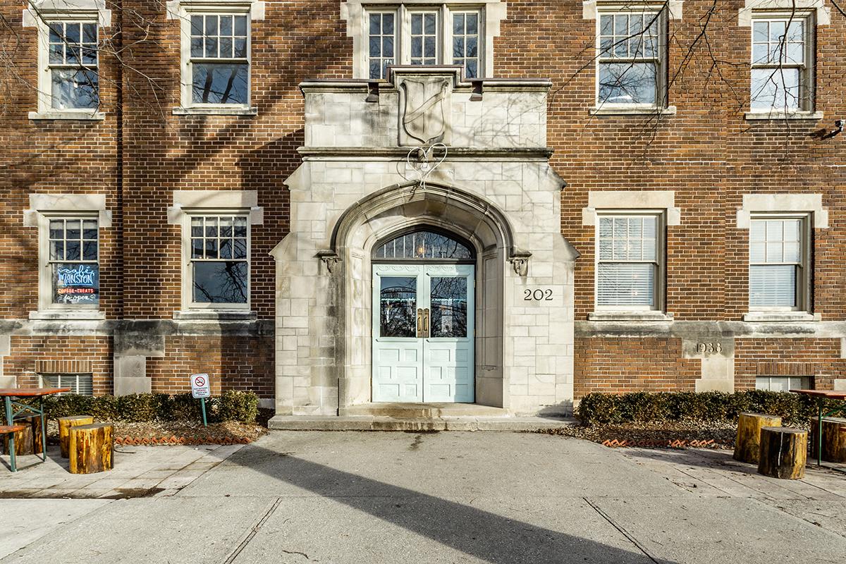 a stone building that has a bench in front of a window