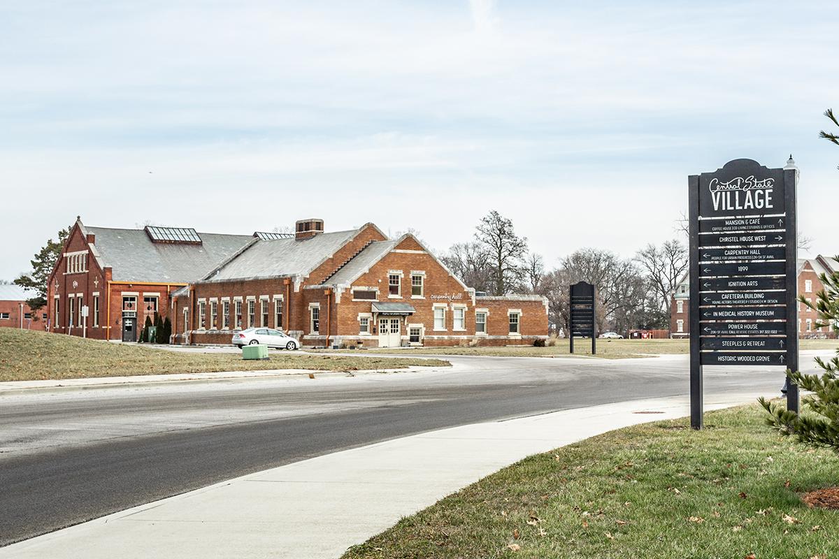 a house that has a sign on the side of a road