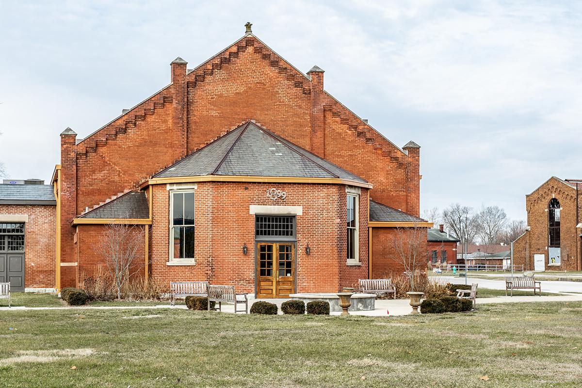 a large brick building with grass in front of a house
