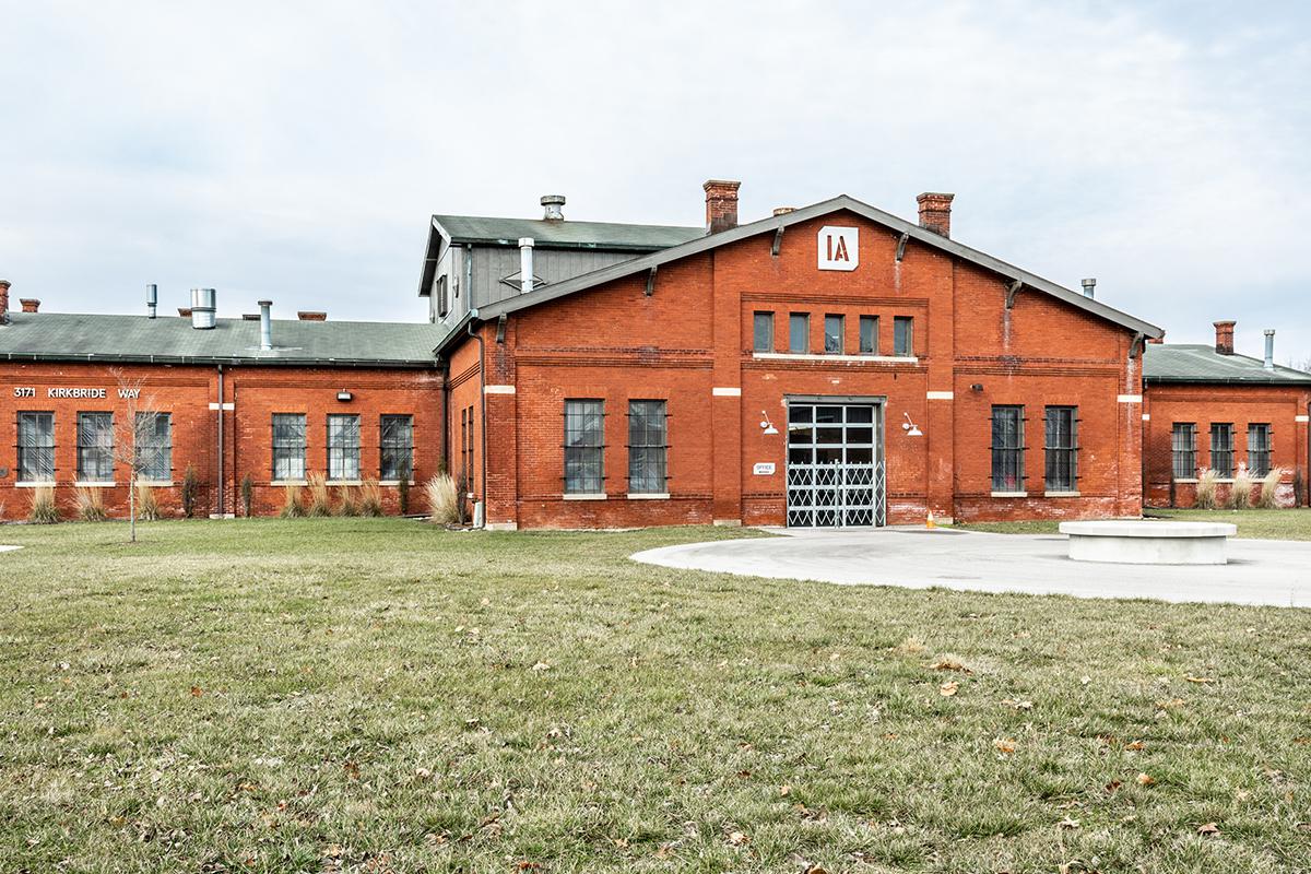 a large brick building with grass in front of a house