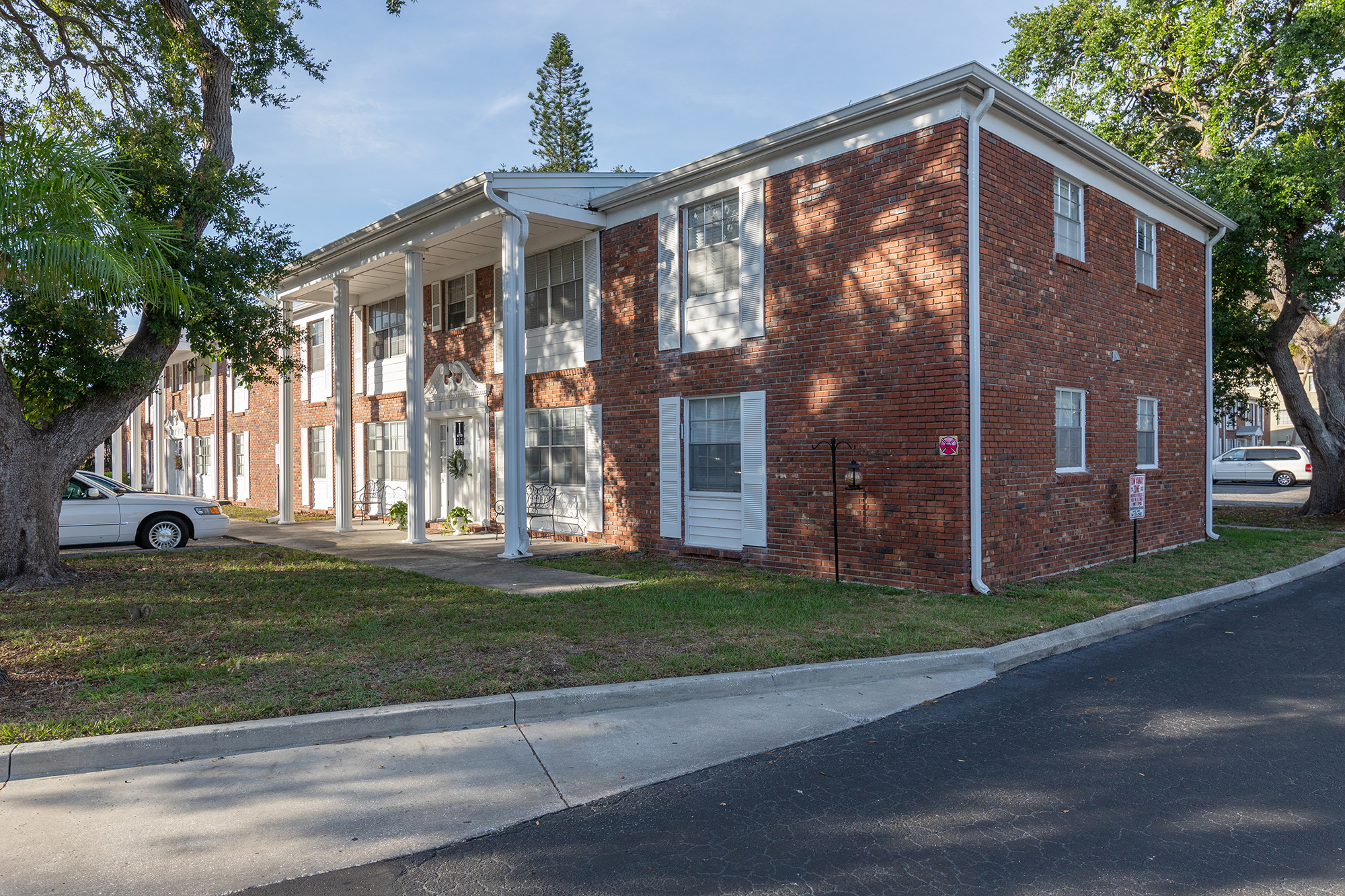 a large brick building with grass in front of a house