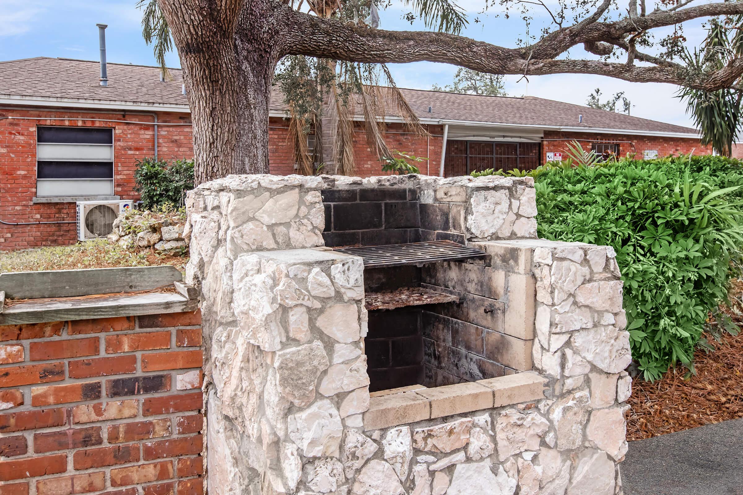 a stone building that has a bench in front of a brick wall