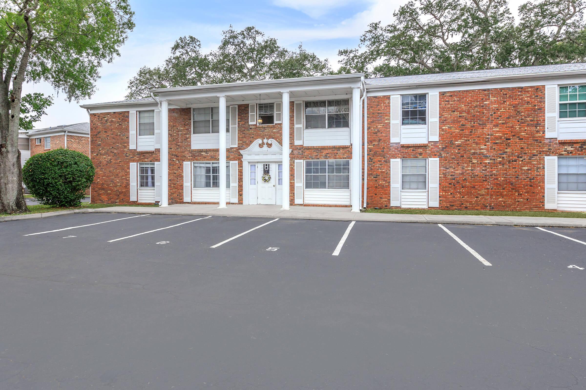 an empty parking lot in front of a brick building