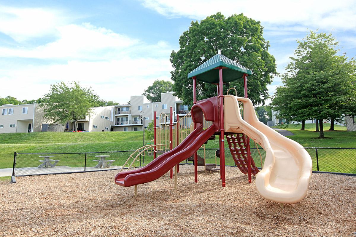 a large red chair in front of a playground