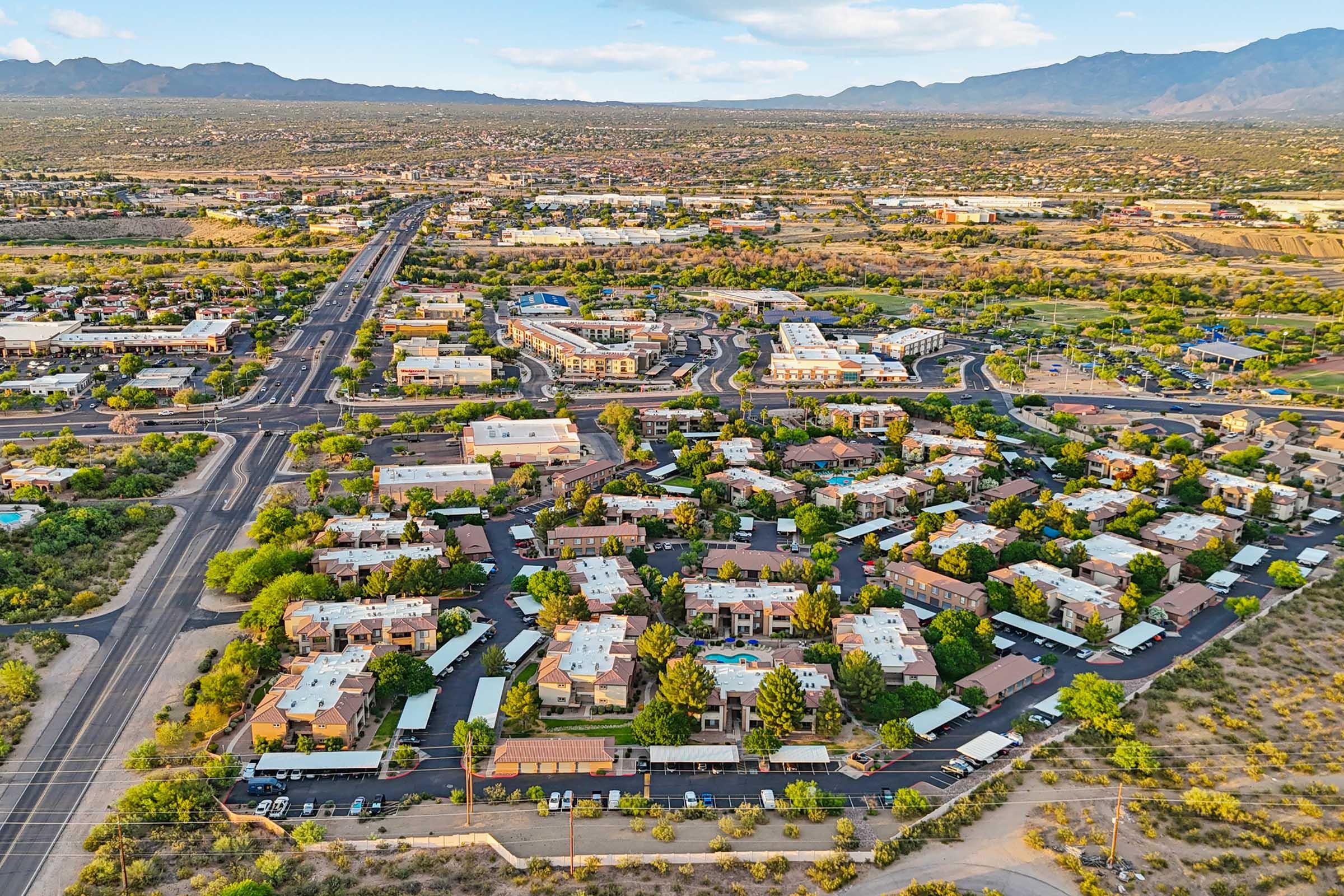 Aerial view of a residential neighborhood with various buildings and landscaping surrounded by roads.