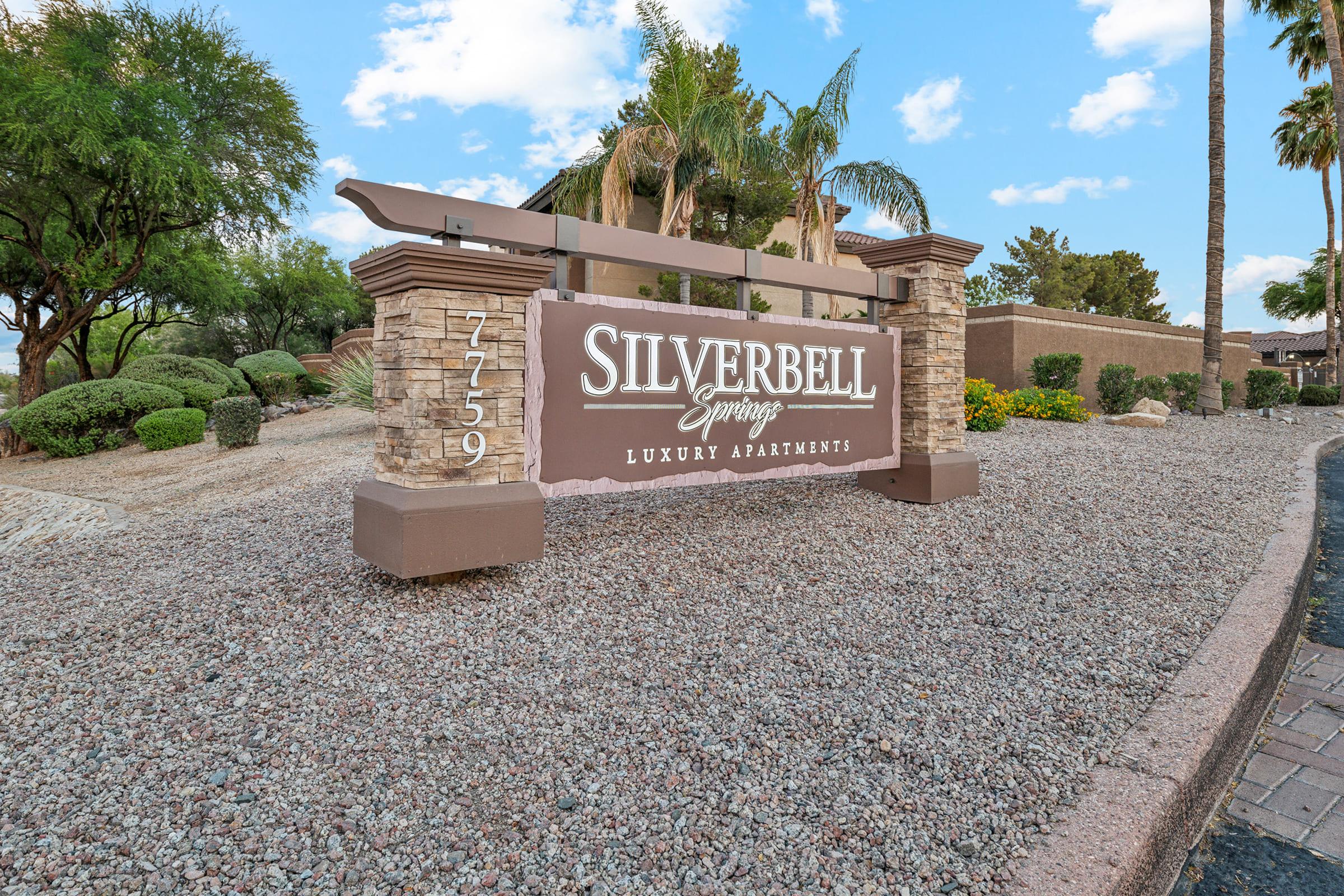 Sign for Silverbell Springs Luxury Apartments, featuring a stone structure with landscaping