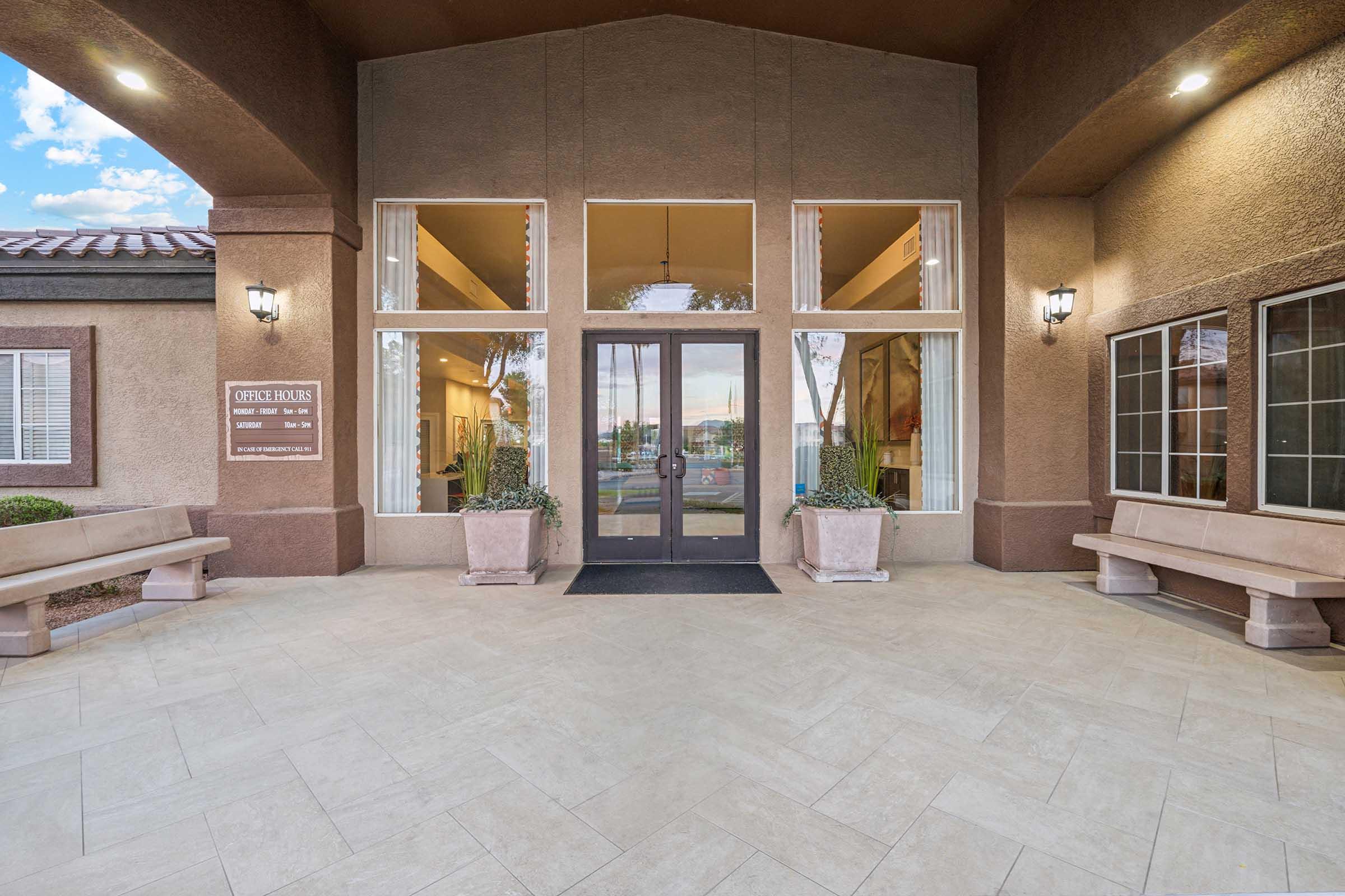 Entrance of a building with glass double doors and large windows.