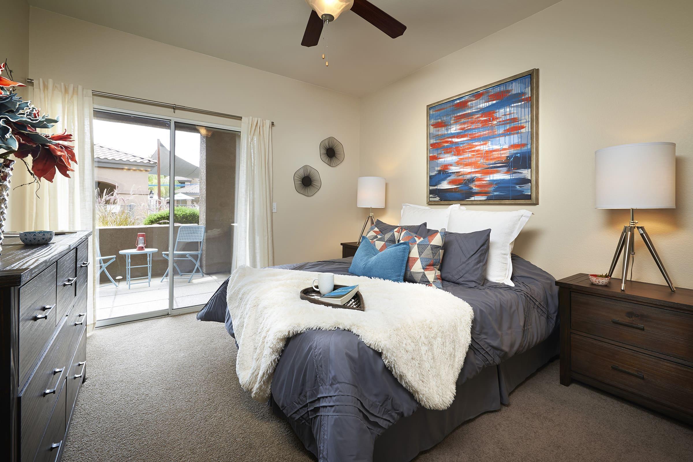 A cozy bedroom featuring a king-sized bed with gray bedding and decorative pillows.